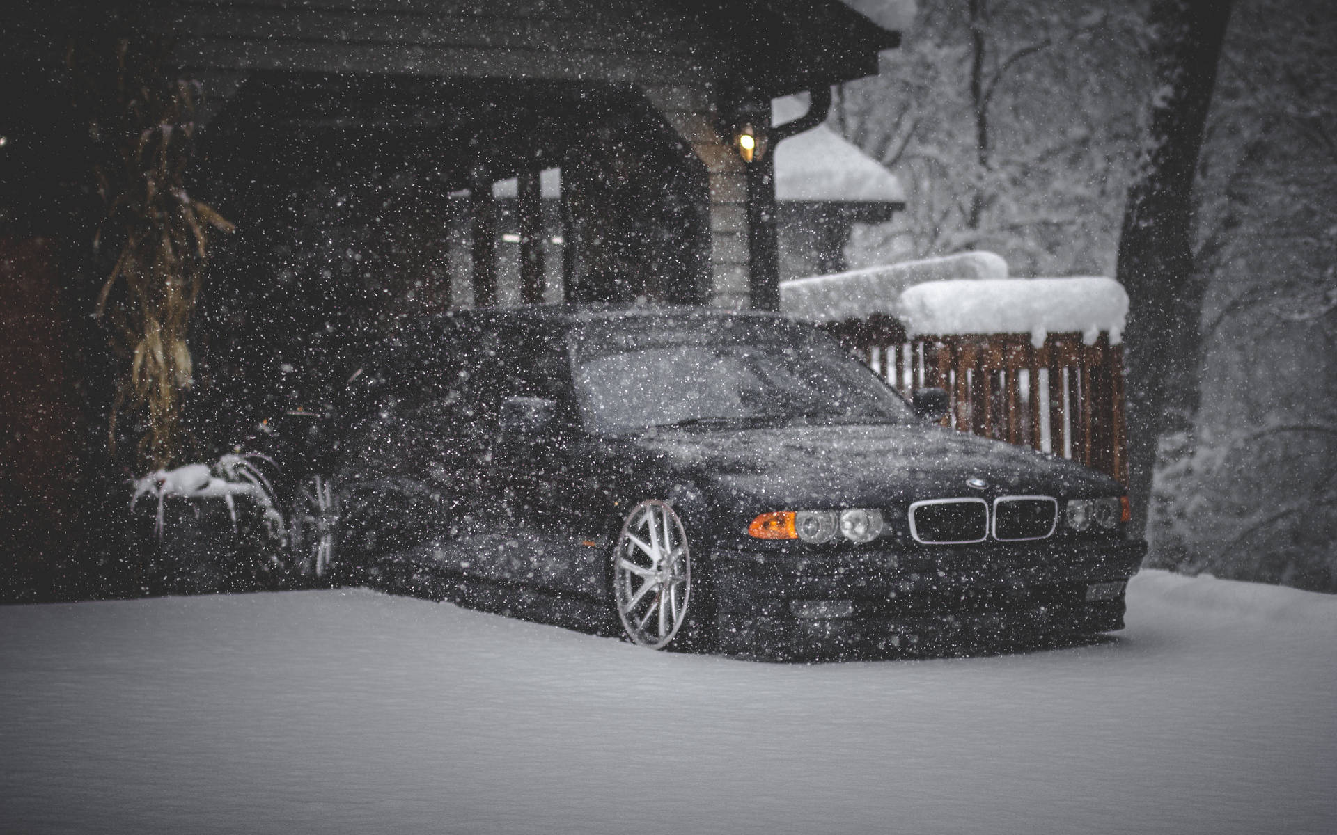 黑色BMW轎車在冬夜停在雪中，雪花飄落。 — BMW 動圖 壁紙