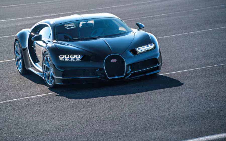 4K 桌布 壁紙 — 一輛時尚的黑色Bugatti Chiron跑車停泊在陽光普照的瀝青賽道上，車門打開。