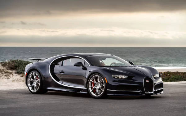 黑色Bugatti Chiron停泊在沿海公路，背景為海洋。 — 4K 壁紙