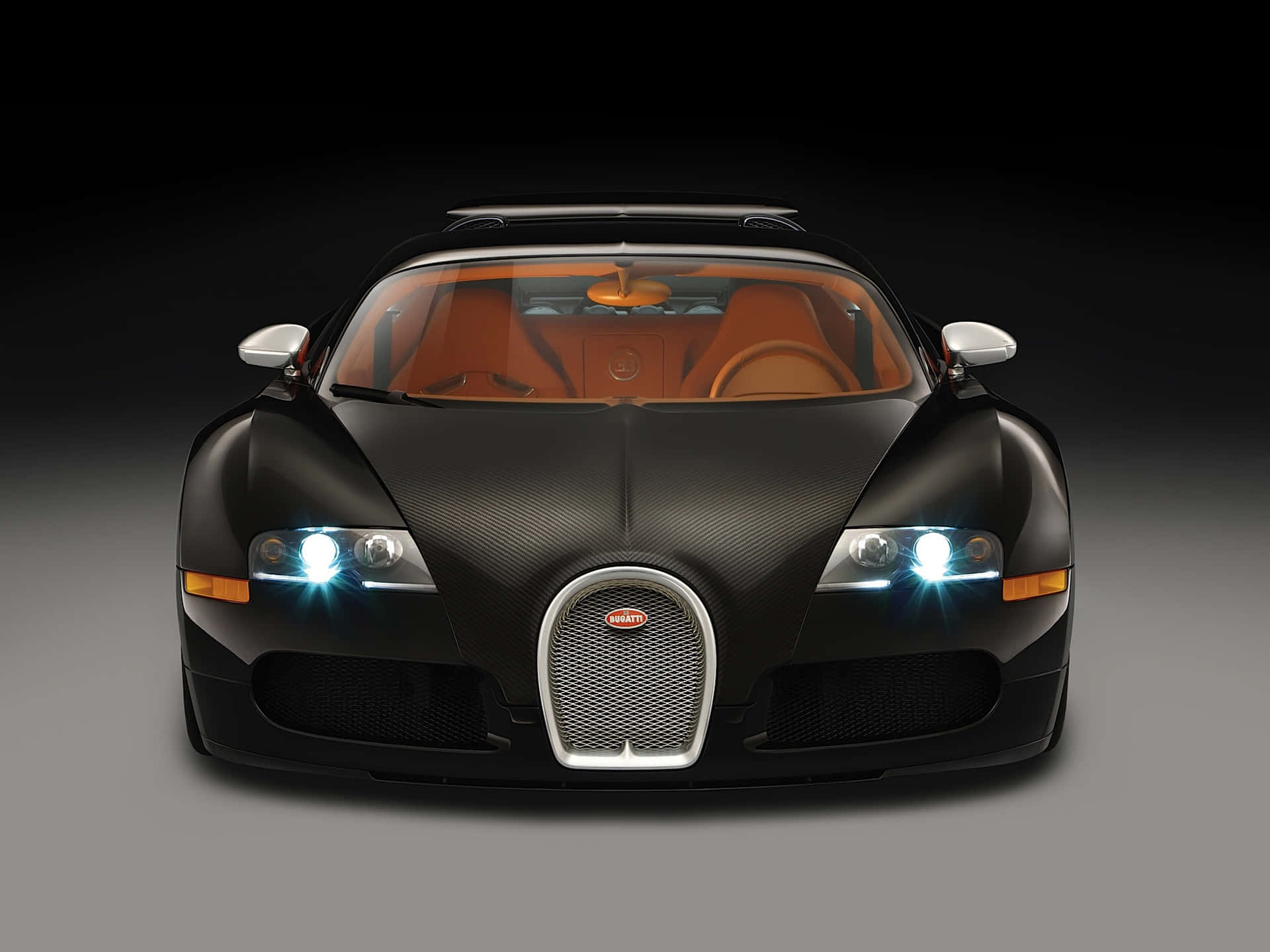 桌布 壁紙 — 一輛時尚的黑色Bugatti Veyron，帶有發光頭燈和橙色內飾，在深色漸變背景前凝視前方。