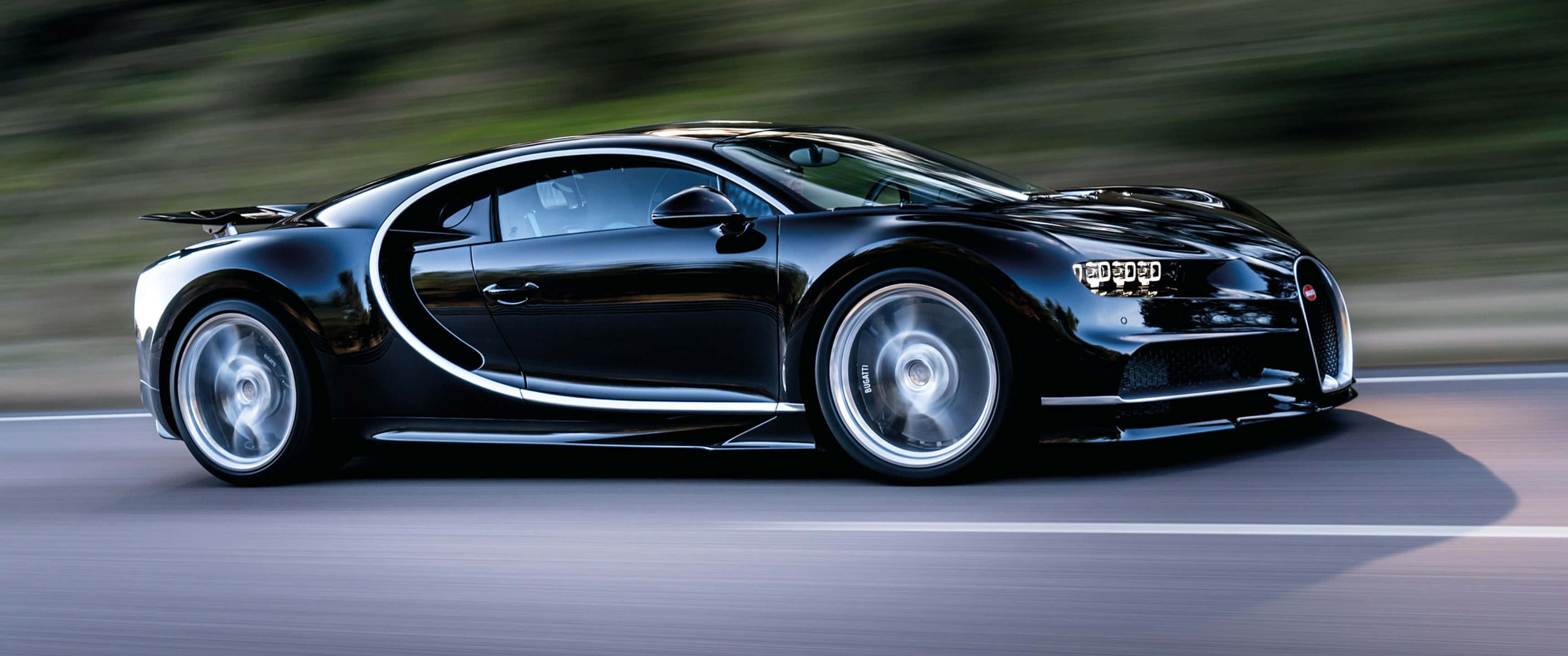 3440x1440p Bugatti 桌布 壁紙 — 一輛時尚的黑色Bugatti Veyron在模糊的道路上飛馳，動態模糊強調其高速。