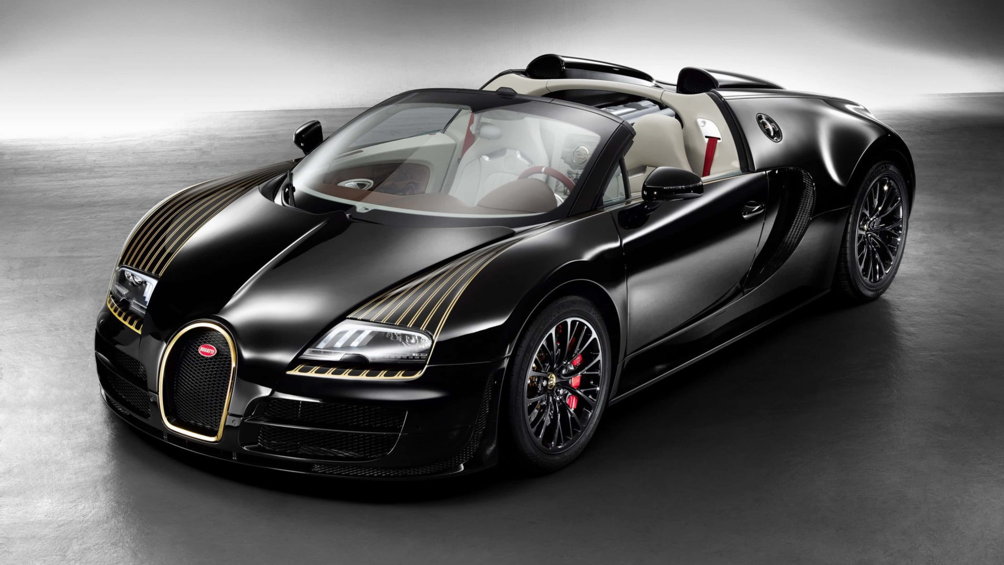 桌布 壁紙 — 一輛時尚的黑色Bugatti Veyron Grand Sport，帶有金色裝飾和紅色制動卡鉗，擺放在極簡灰色工作室地板上。