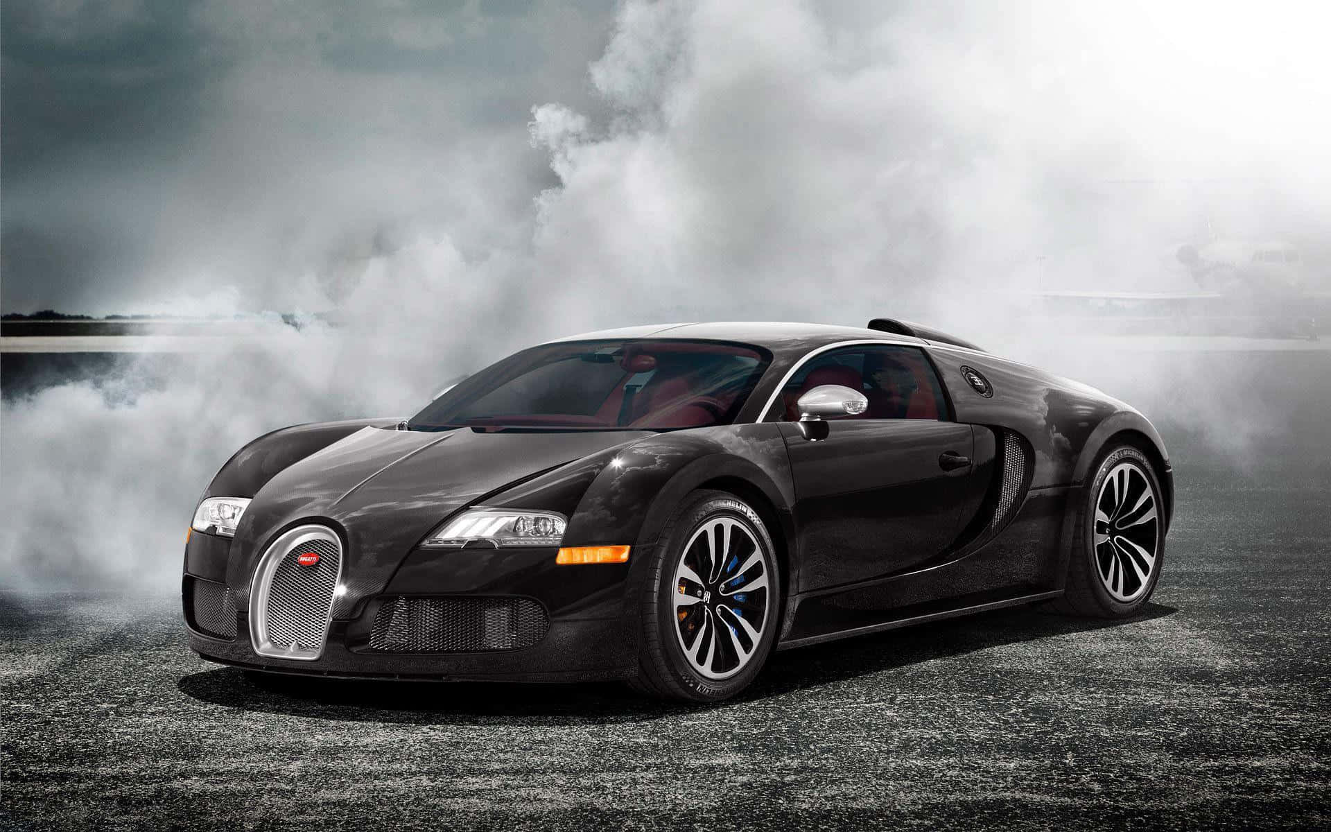 Best Bugatti 桌布 壁紙 — 一輛時尚的黑色Bugatti Veyron在暴風雨天空下的濕瀝青路面上戲劇性地冒煙。