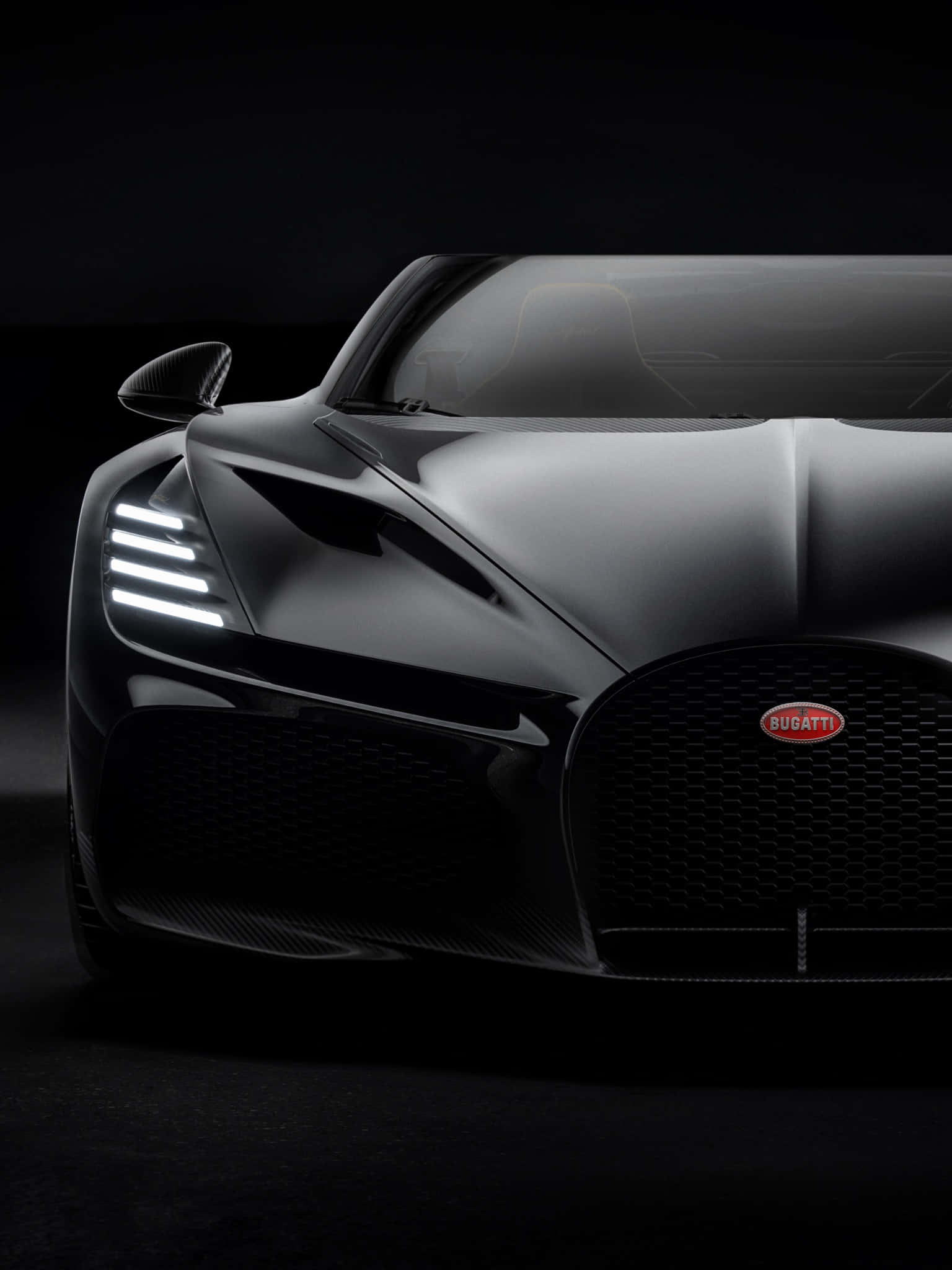 Bugatti Phone 桌布 壁紙 — 一輛時尚的黑色Bugatti超級跑車在黑暗的攝影棚背景下散發出銳利的白色車頭燈光芒。