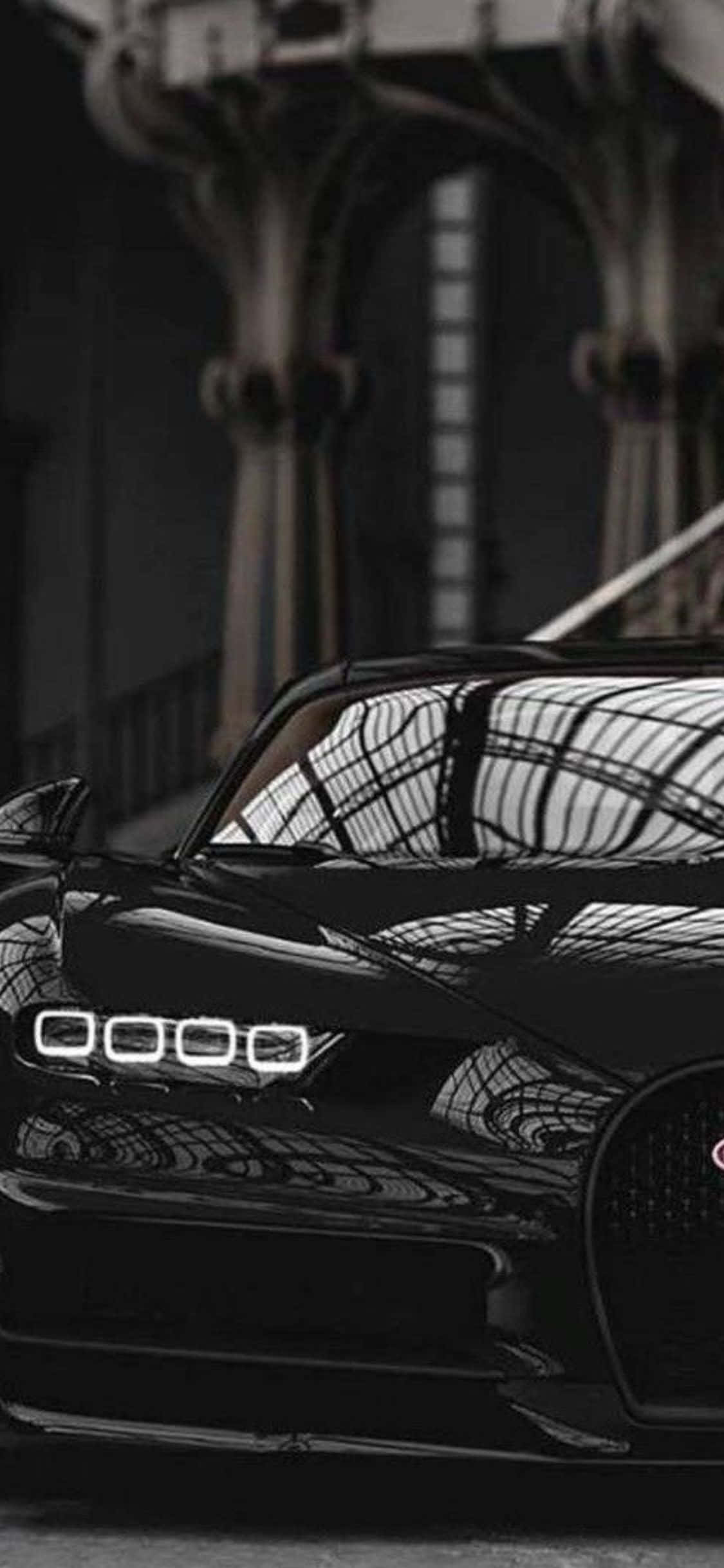 iPhone Xs Bugatti 桌布 壁紙 — 一輛時尚的黑色Bugatti跑車在拱形窗戶的宏偉哥德式大廳內，於柔和燈光下閃閃發光。