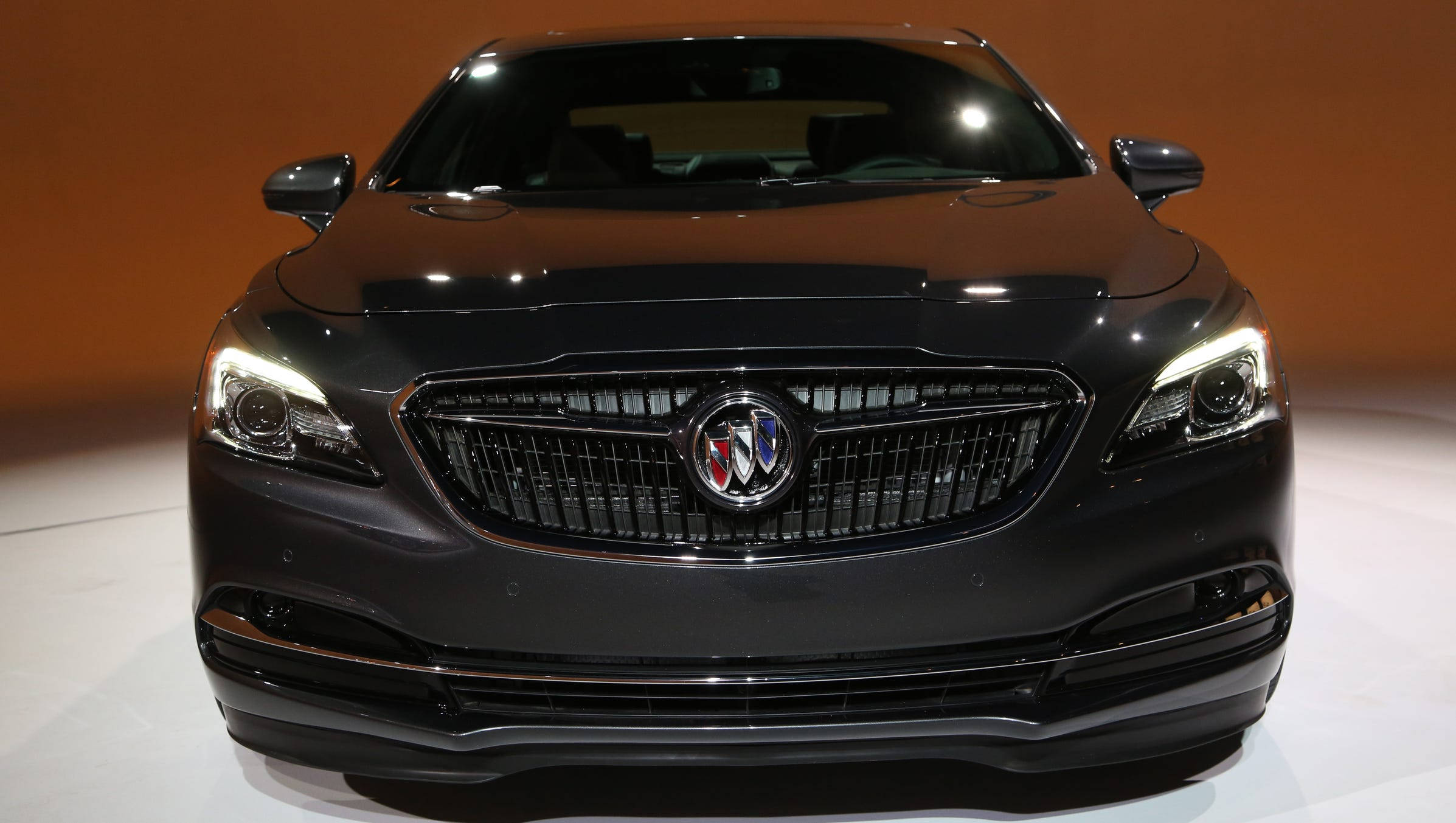 Buick 桌布 壁紙 — 一輛時尚的黑色Buick豪華轎車在明亮的燈光下，在純白色的展廳地板上閃閃發光。