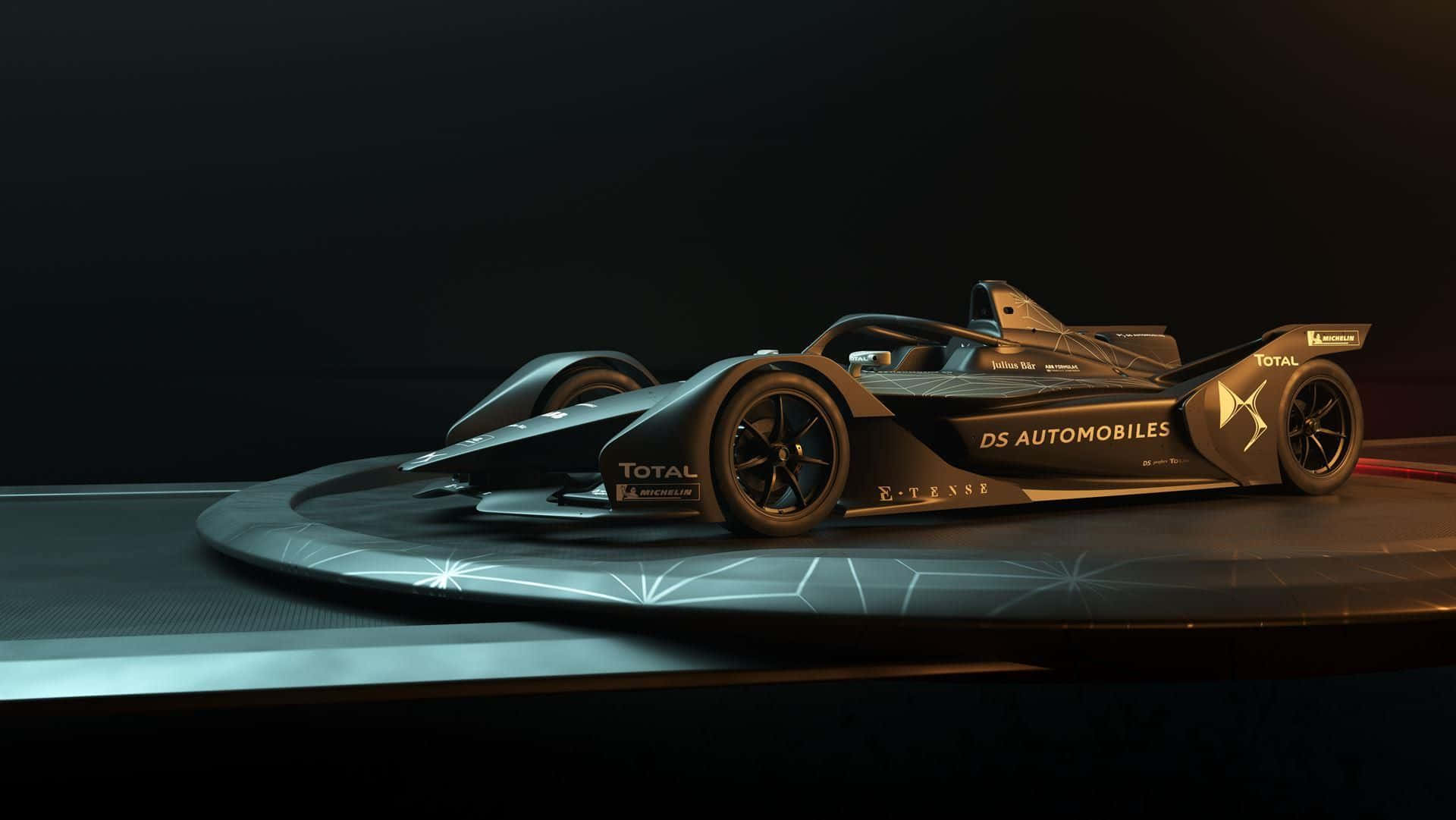 Ds Automobiles 桌布 壁紙 — 一輛時尚的黑色DS Automobiles Formula E賽車在黑暗背景下的圓形平台上，在戲劇性燈光下閃耀。