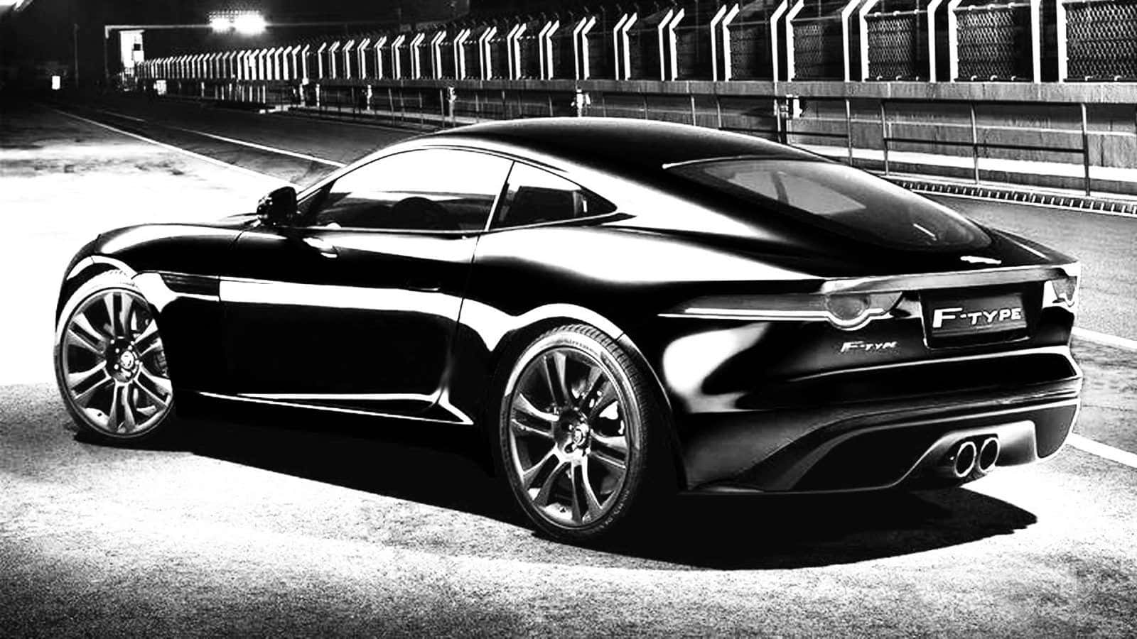 Black And White Car 桌布 壁紙 — 一輛時尚的黑色Jaguar F-Type跑車在賽道上的夜燈下閃閃發光。