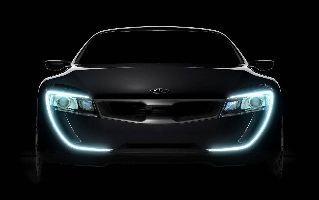 Kia 桌布 壁紙 — 一輛時尚的黑色Kia概念車在純黑色背景下發出明亮的藍色車頭燈光芒。