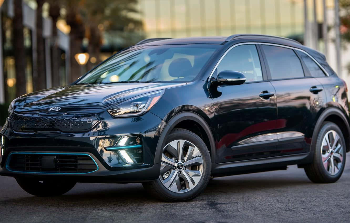 Kia Niro 桌布 壁紙 — 一輛時尚的黑色Kia電動SUV停放在城市街道上，溫暖的黃金時刻光線反射在其光滑表面上。