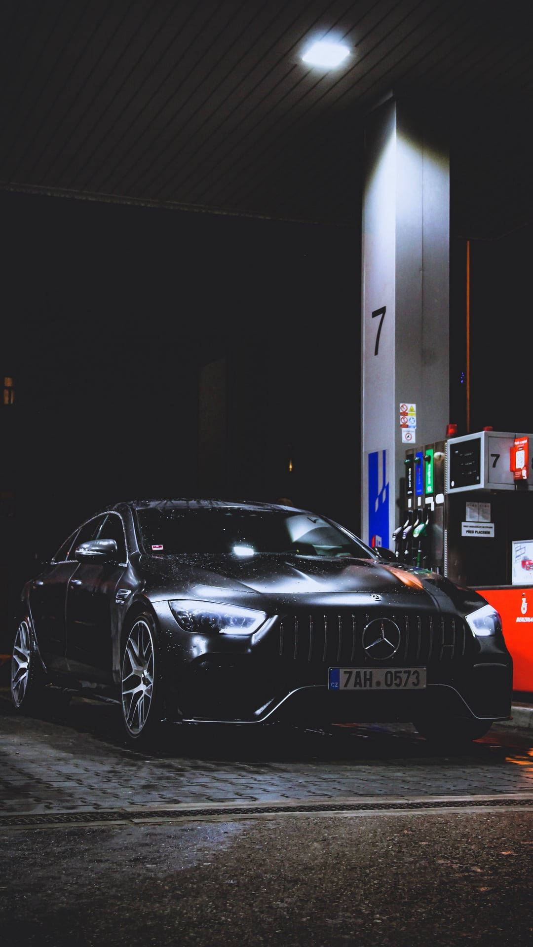 Gas Station 桌布 壁紙 — 一輛時尚的黑色Mercedes-AMG在夜間停放在一個明亮燈光下的加油站油泵旁。