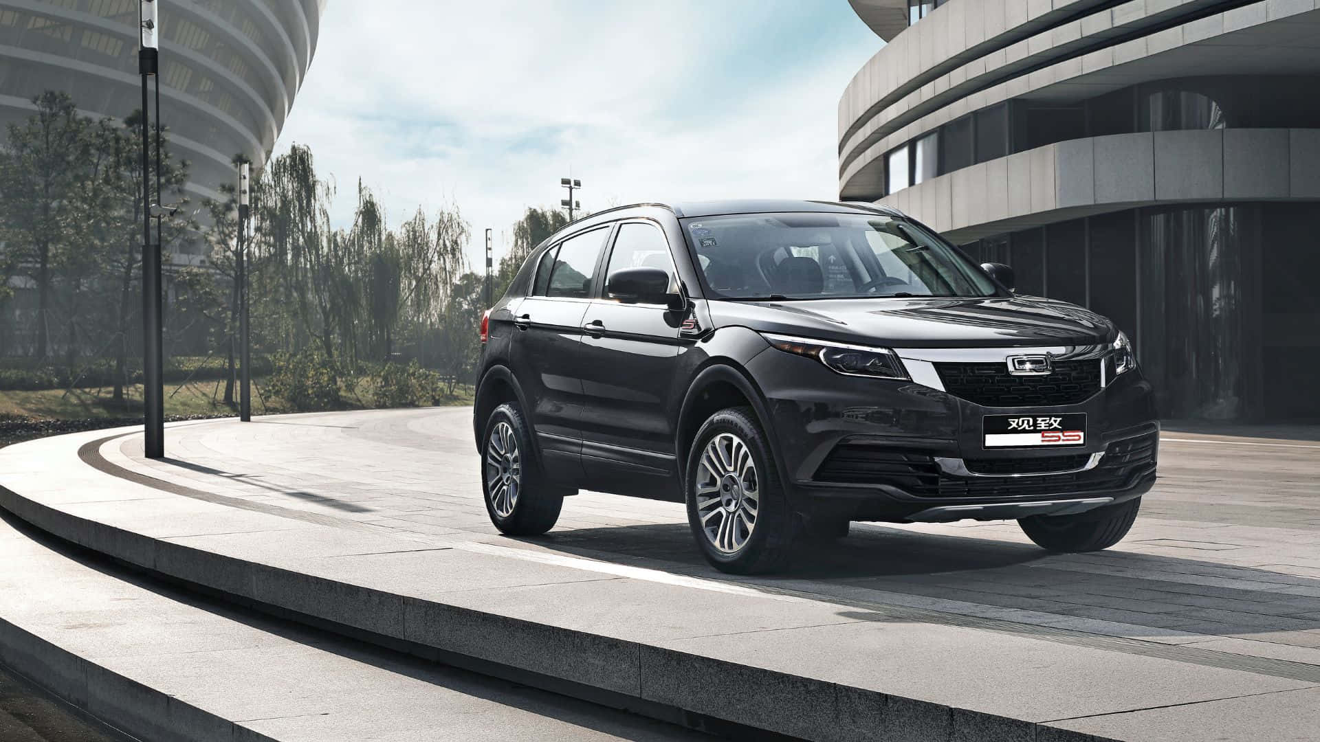 Qoros 桌布 壁紙 — 一輛時尚的黑色SUV停放在彎曲的現代混凝土小徑上，旁邊是未來主義風格的彎曲建築，在明亮的白天天空下。
