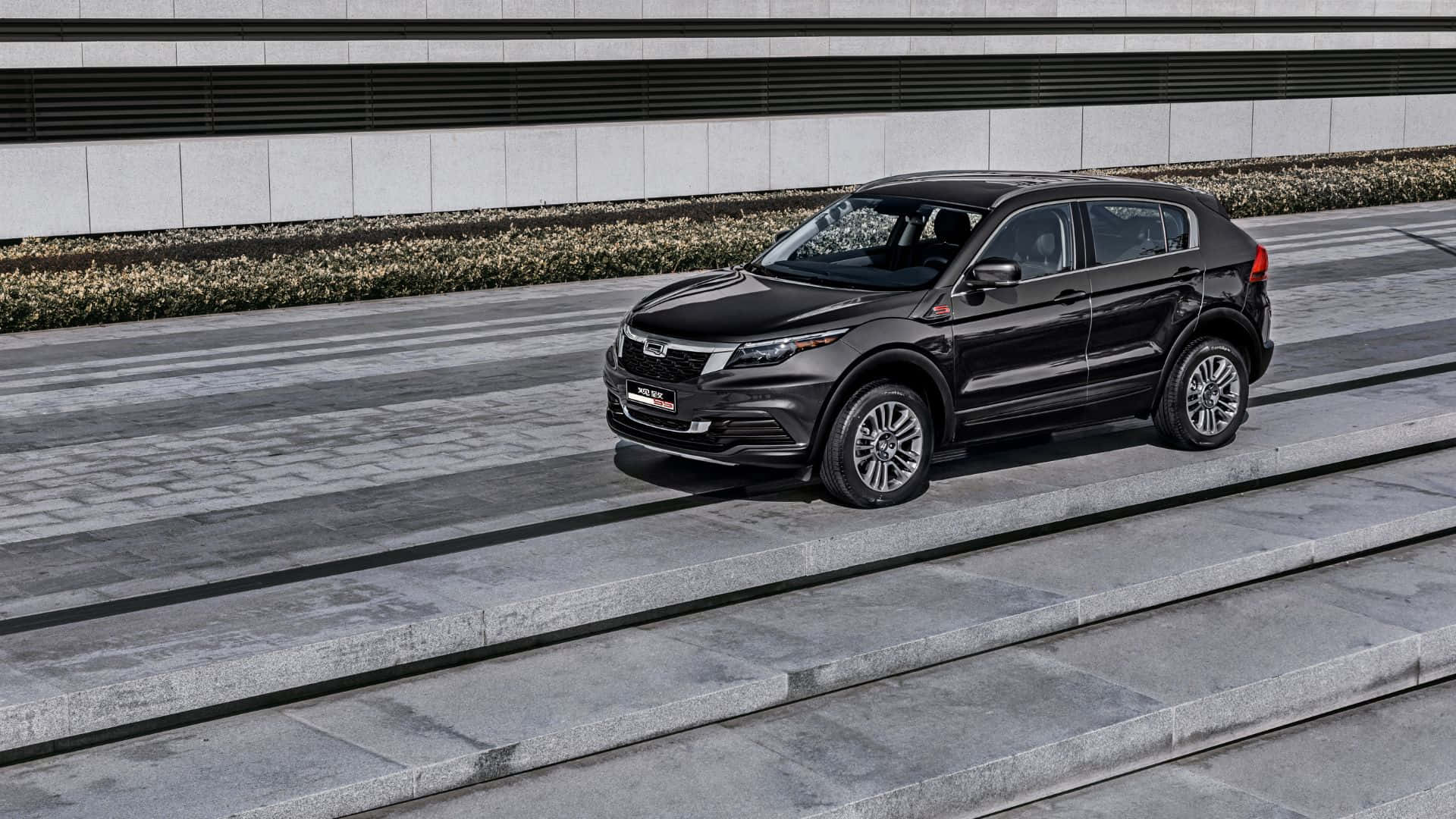 Qoros 桌布 壁紙 — 一輛時尚的黑色SUV停放在現代混凝土台階上，旁邊是簡約的灰色牆壁和低矮的樹籬。