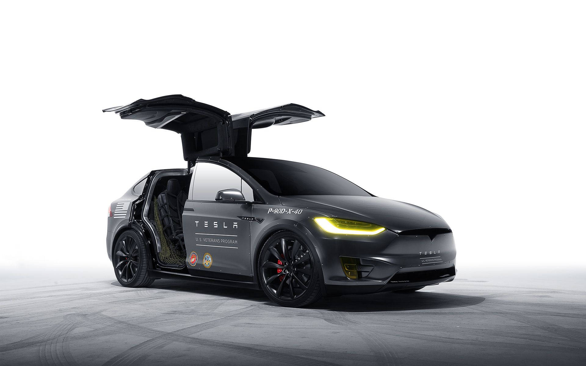 特斯拉 桌布 壁紙 — 一輛時尚的黑色Tesla Model X，鷹翼門打開，車頭燈發光，並帶有美國退伍軍人計劃貼紙，位於簡約的攝影棚地板上。