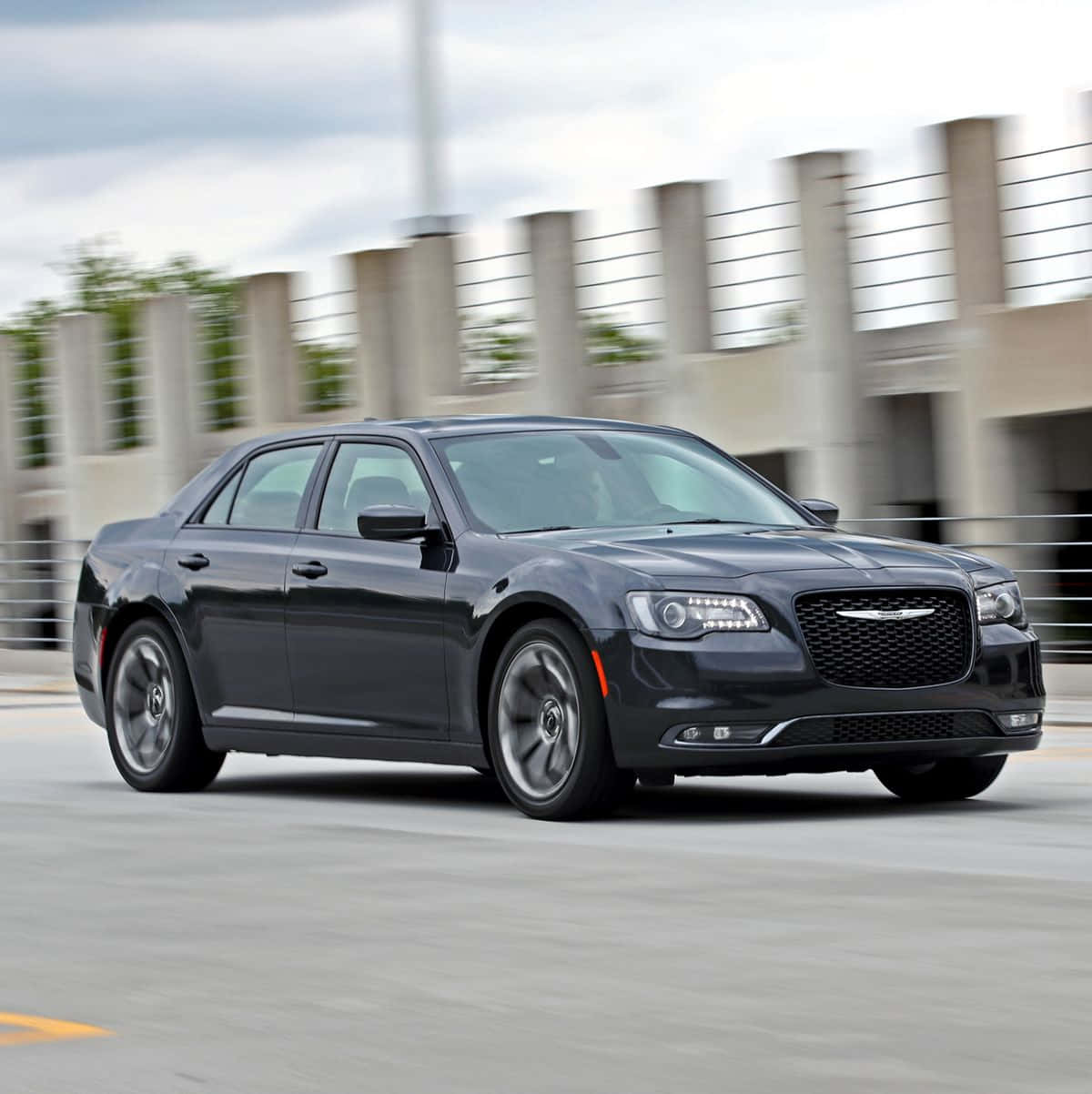 Chrysler 桌布 壁紙 — 一輛時尚的黑色克萊斯勒轎車在混凝土高架橋上疾馳，車輪和背景呈現動態模糊效果。