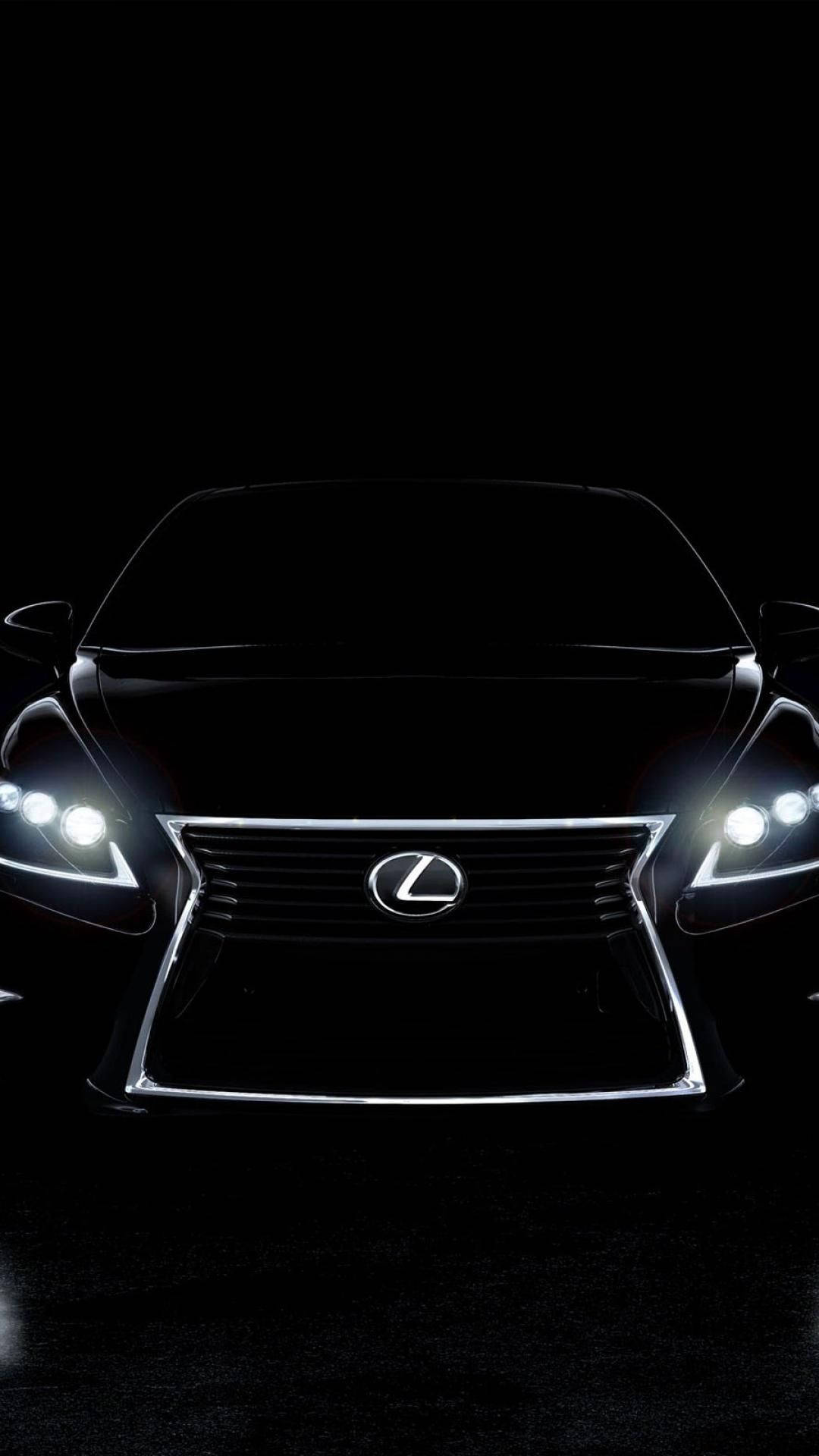 lexus logo 桌布 壁紙 — 一輛時尚的黑色凌志轎車，在漆黑背景下閃爍著銳利的車頭燈。