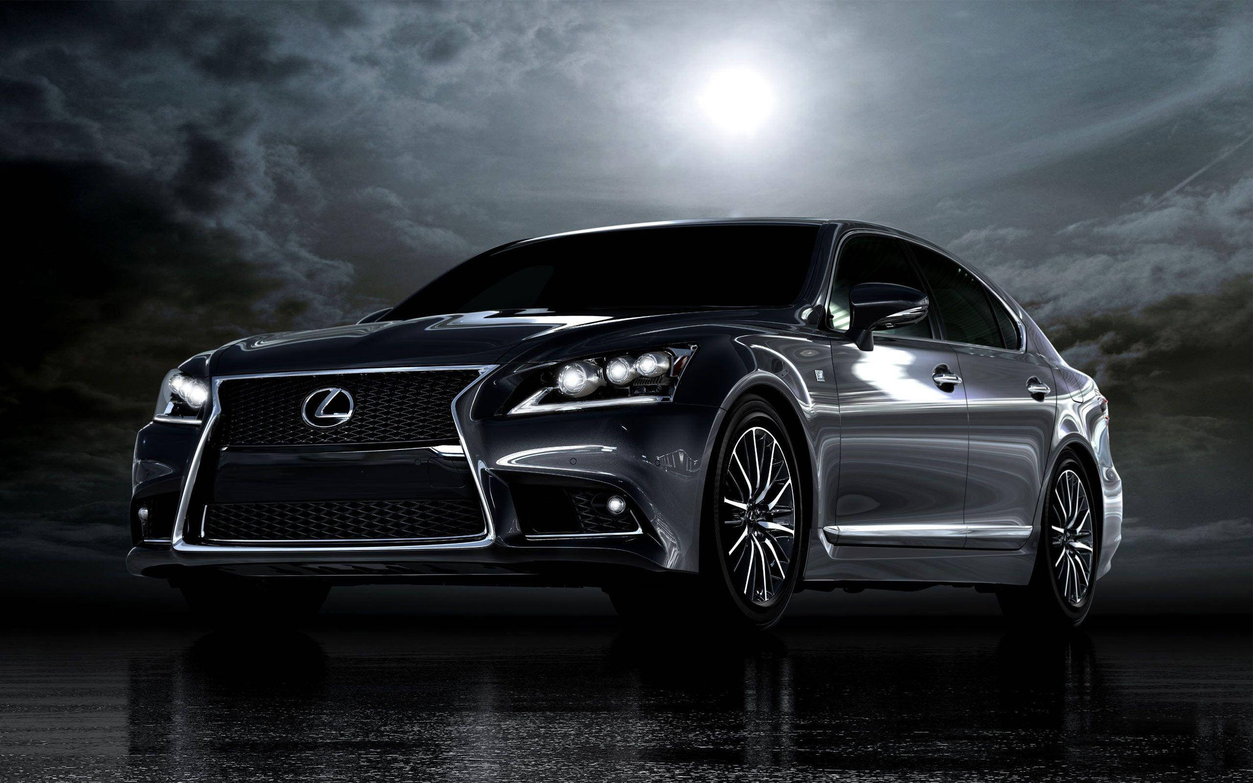 Lexus 標誌 桌布 壁紙 — 一輛時尚的黑色凌志轎車在明亮的月光下閃耀，背景是暴風雨的夜空，潮濕的反光路面。