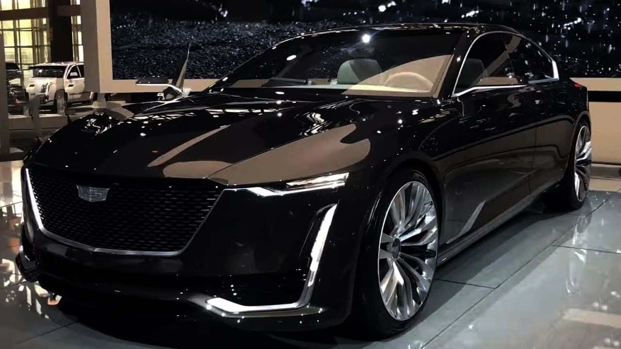 Family Car 桌布 壁紙 — 一輛時尚的黑色凱迪拉克概念車在展廳燈光下閃耀，帶有鍍鉻裝飾和未來主義設計。