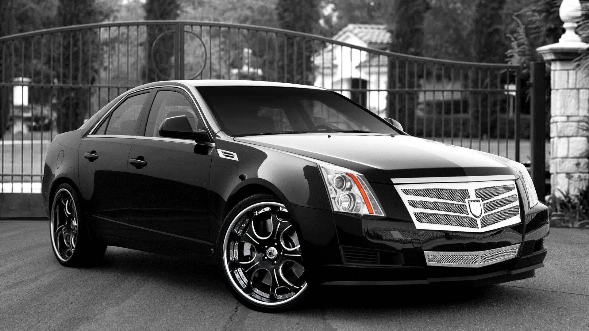 Cadillac 桌布 壁紙 — 一輛時尚的黑色凱迪拉克轎車配備定制輪圈，單色調停放在華麗的大門前。