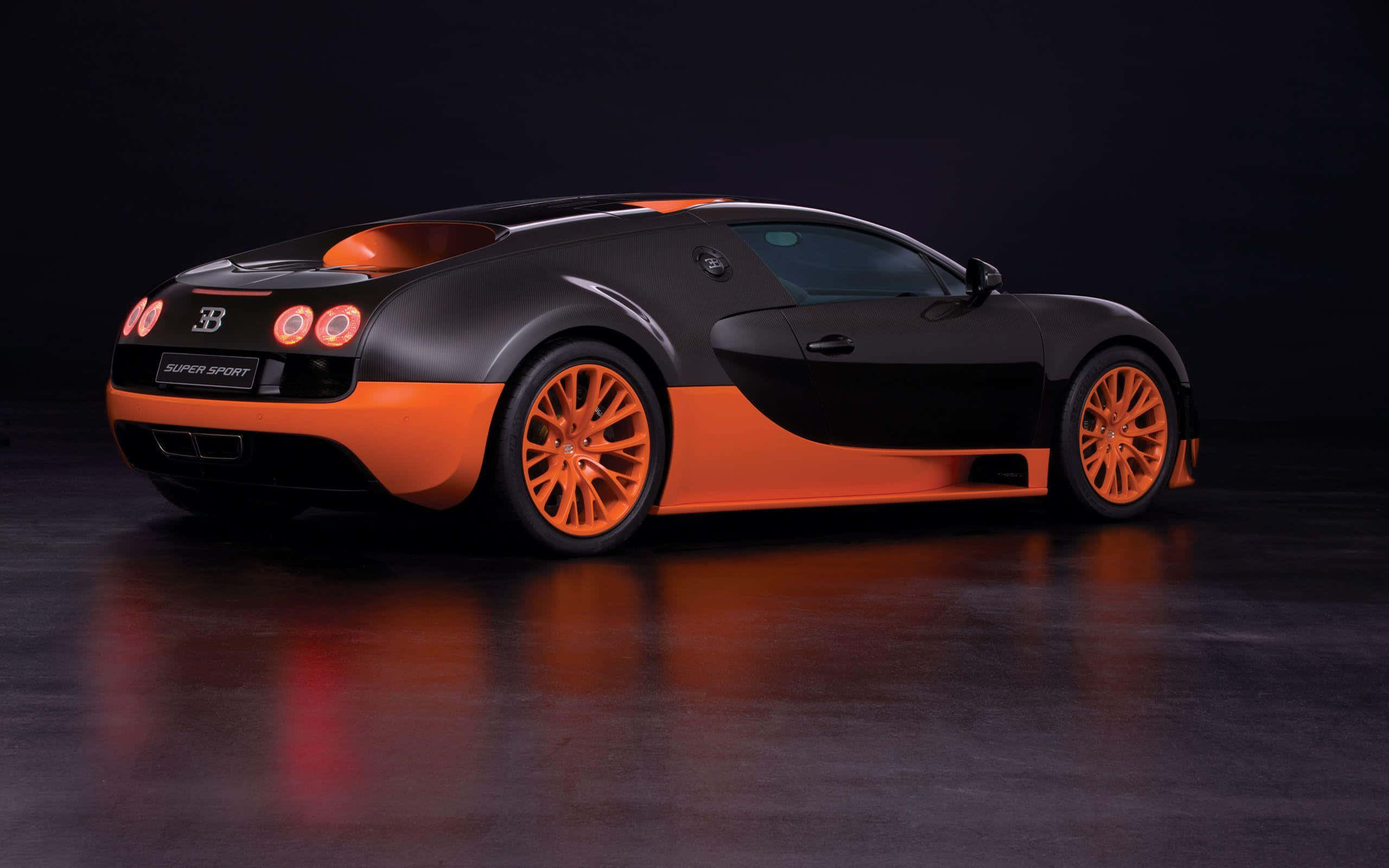 布加迪 桌布 壁紙 — 一輛時尚的黑色和橙色Bugatti Super Sport跑車在攝影棚燈光下，在深色反光地板上閃耀。