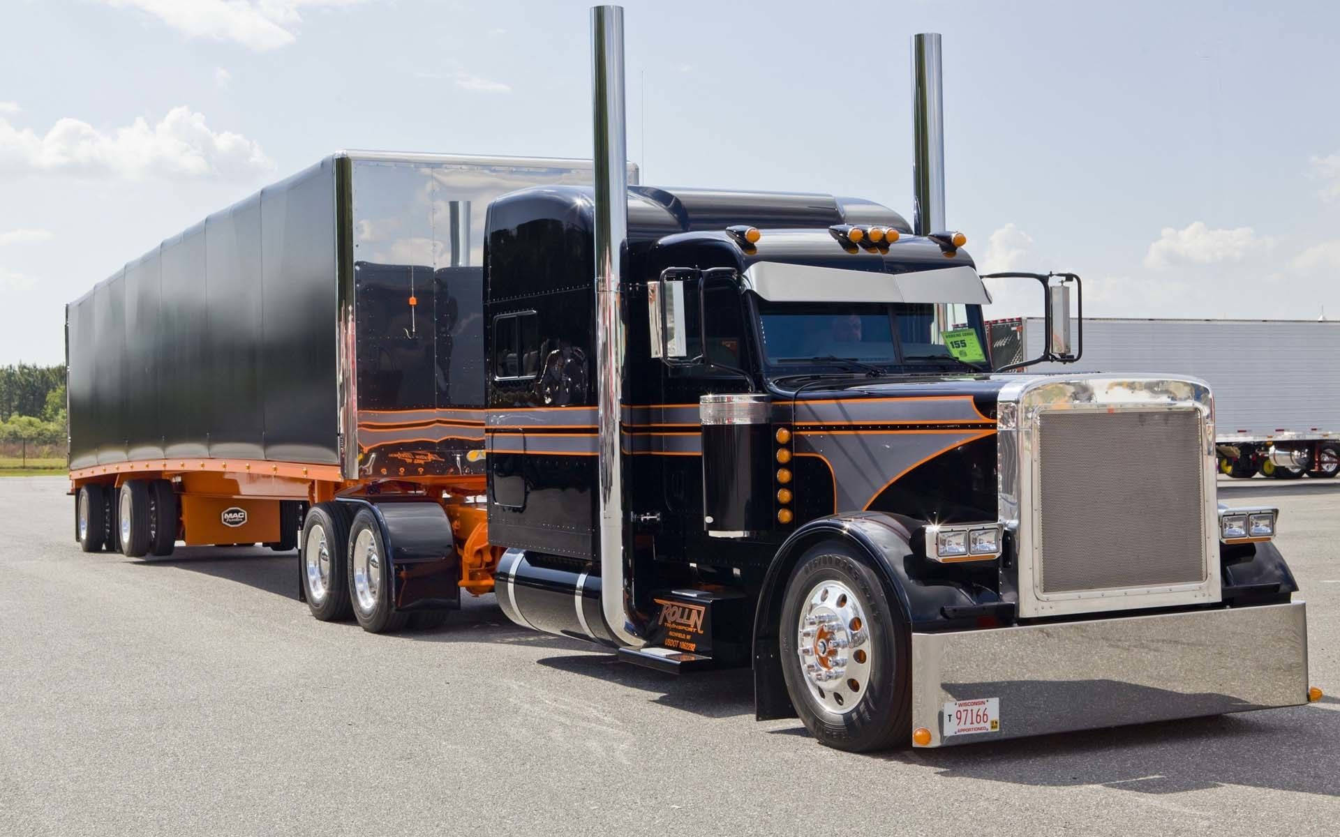 Trucks 桌布 壁紙 — 一輛時尚的黑色和橙色半掛卡車，帶有鍍鉻裝飾和高排氣管，停在明亮的天空下的瀝青路面上。