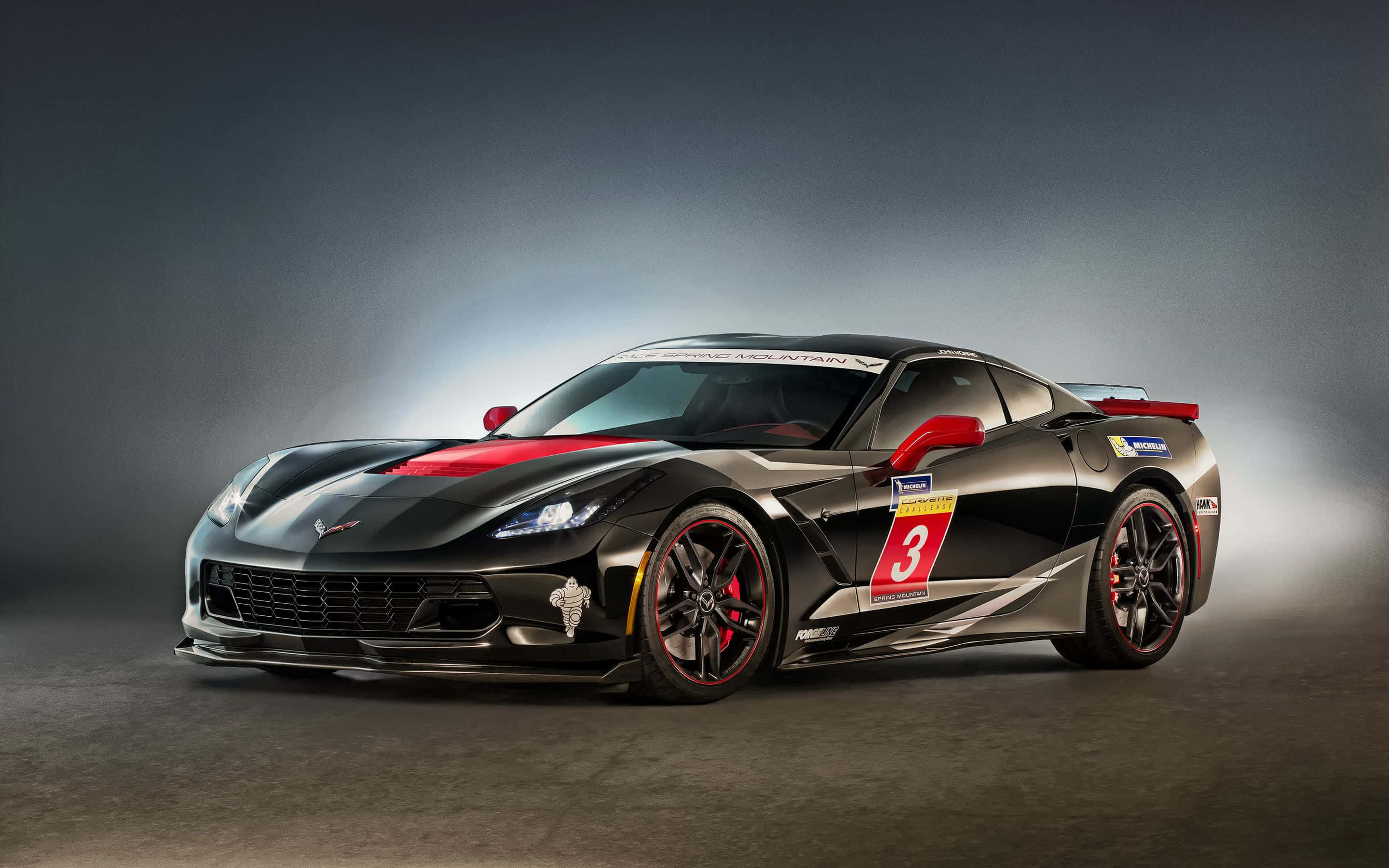 Chevrolet Corvette Stingray 桌布 壁紙 — 一輛時尚的黑色和紅色賽車，側面有數字3，在黑暗的攝影棚背景下戲劇性地被照亮。
