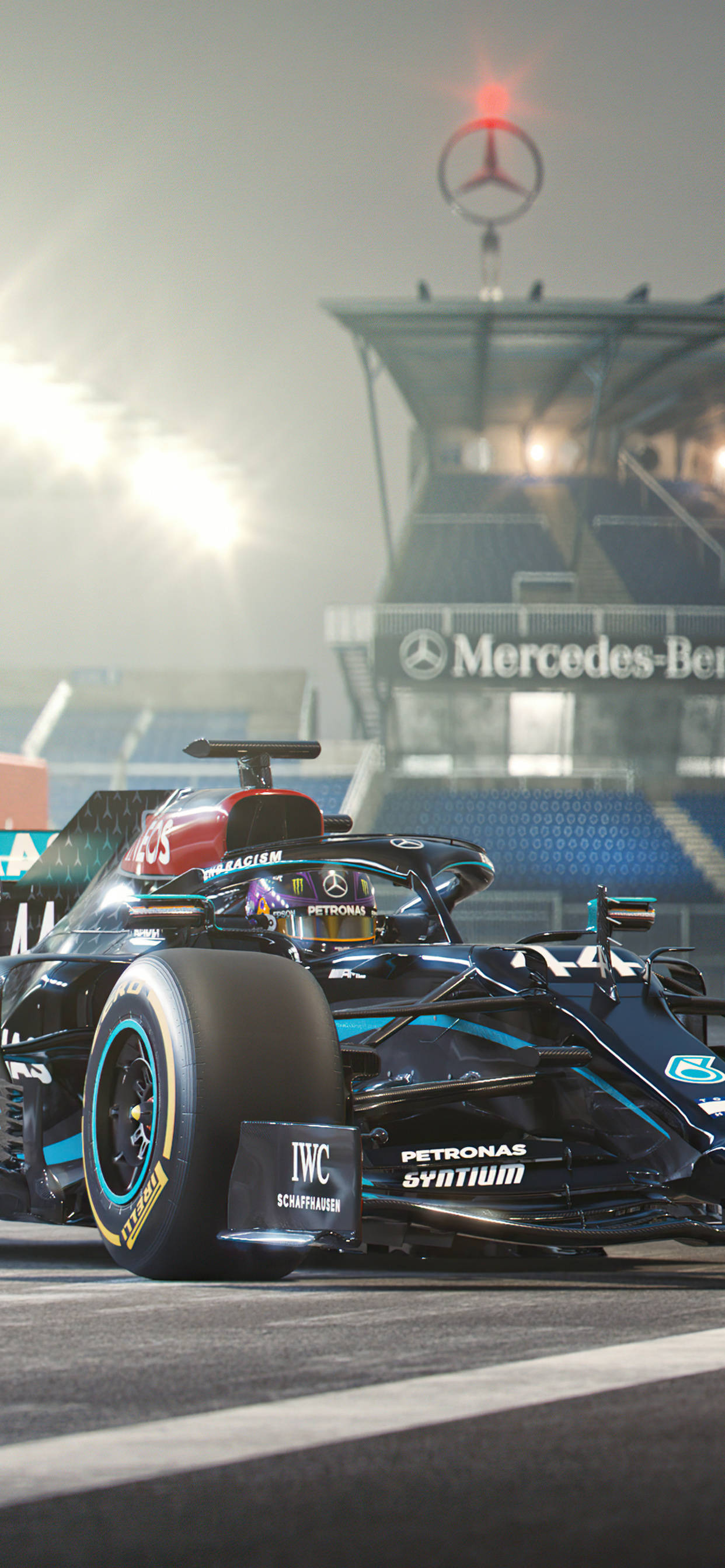 Mercedes 桌布 壁紙 — 一輛時尚的黑色和藍綠色賓士一級方程式賽車在明亮的體育場燈光下在賽道上奔馳，背景是賓士大廈。