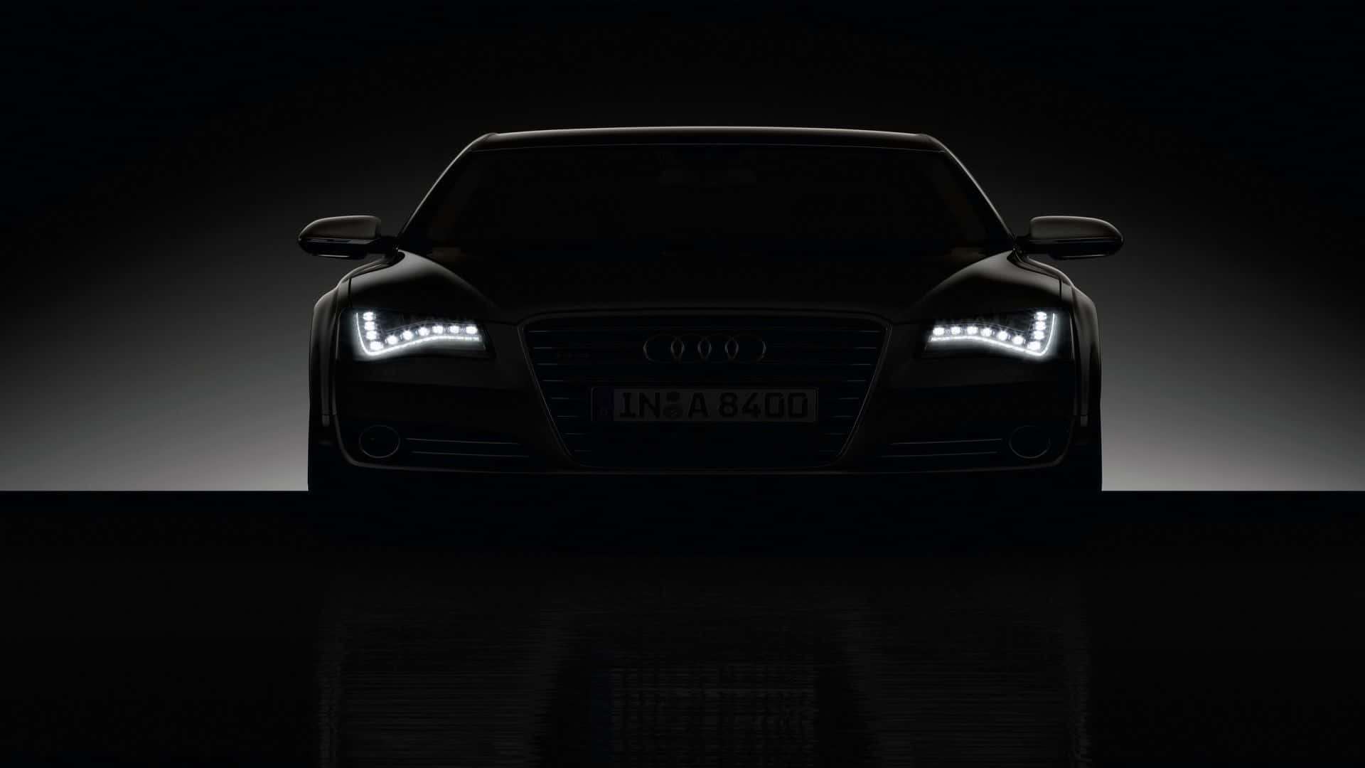 Black Car 4K 桌布 壁紙 — 一輛時尚的黑色奧迪汽車在深色漸變工作室背景襯托下，散發出銳利的LED頭燈光芒。