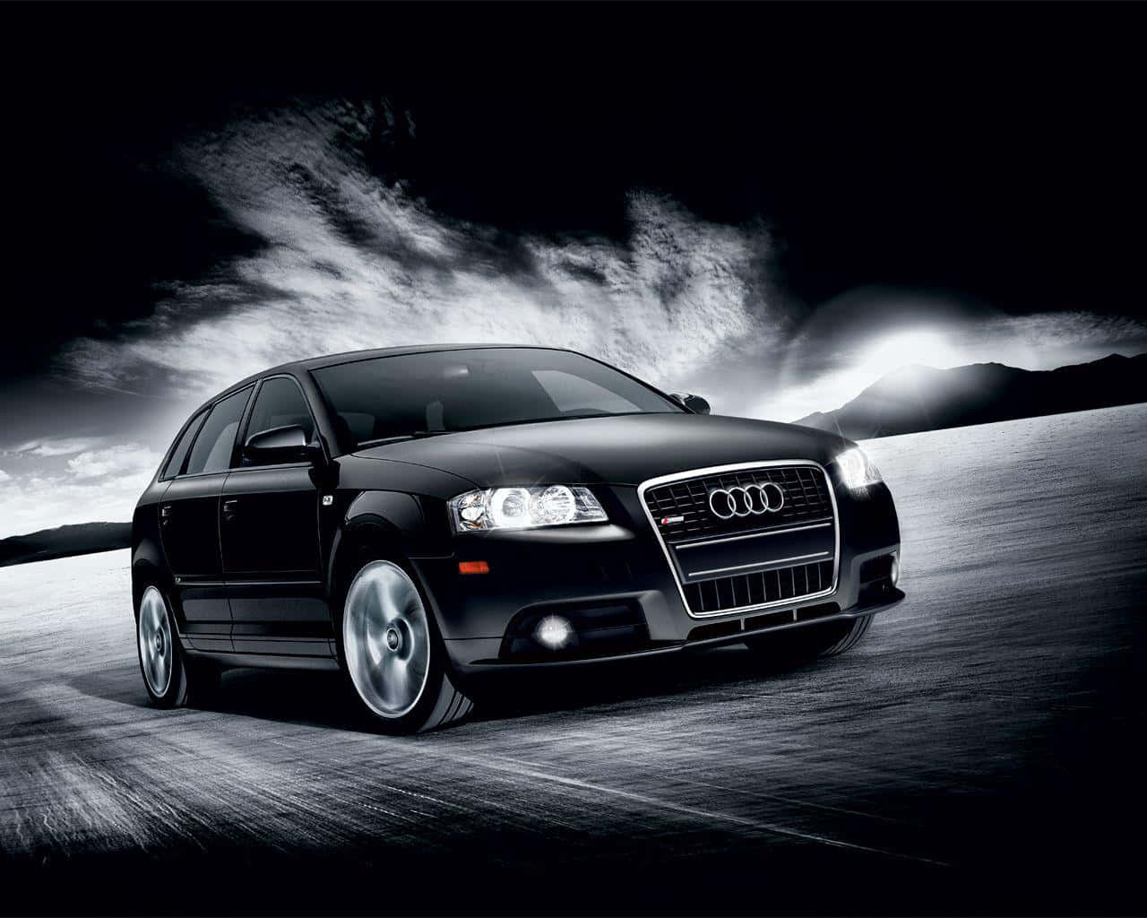 Audi A3 桌布 壁紙 — 一輛時尚的黑色奧迪跑車在暴風雨夜空的戲劇性燈光下，在黑暗的沙漠公路上疾馳。