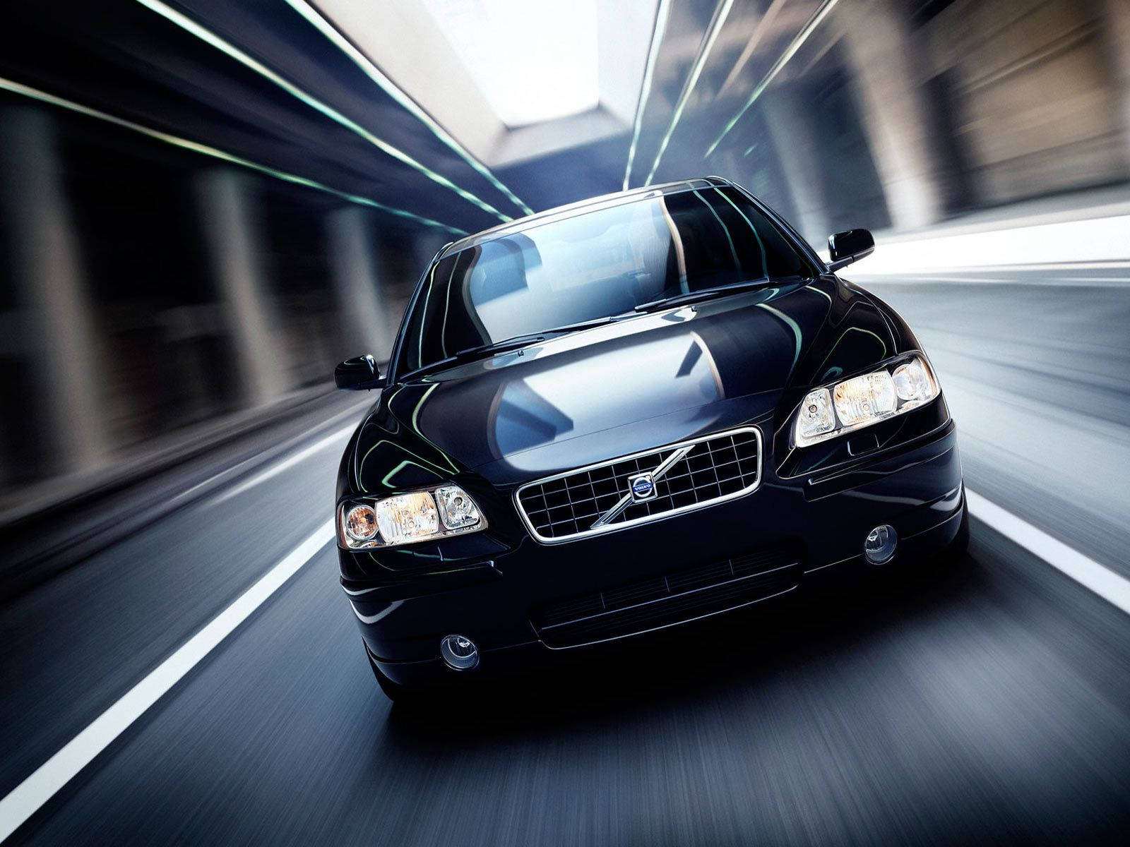 Volvo 桌布 壁紙 — 一輛時尚的黑色富豪房車在隧道中疾馳，動態模糊效果劃過混凝土牆壁和發光的頂燈。