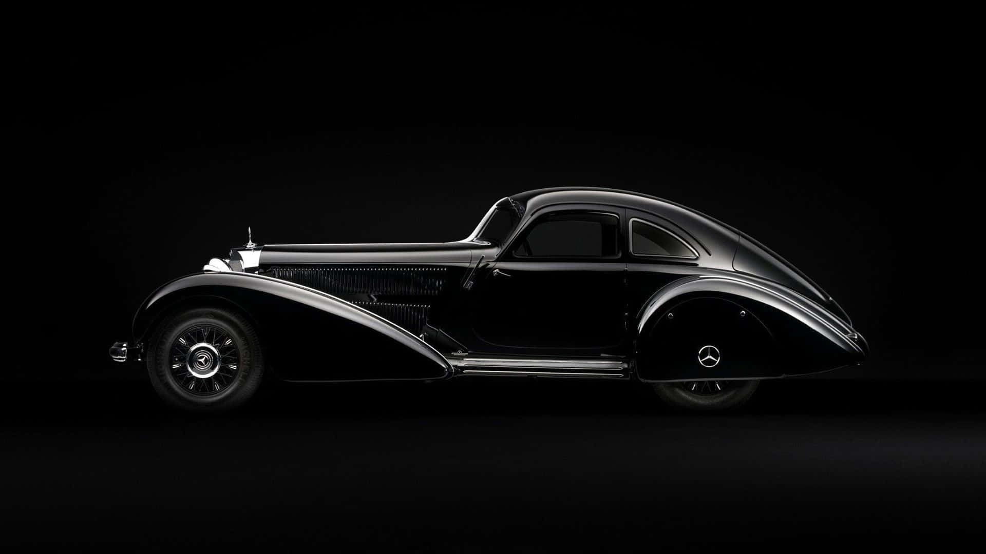 Black And White Vintage Car 桌布 壁紙 — 一輛時尚的黑色復古梅賽德斯-奔馳轎跑車在純黑色背景下，在戲劇性的工作室燈光下閃耀。