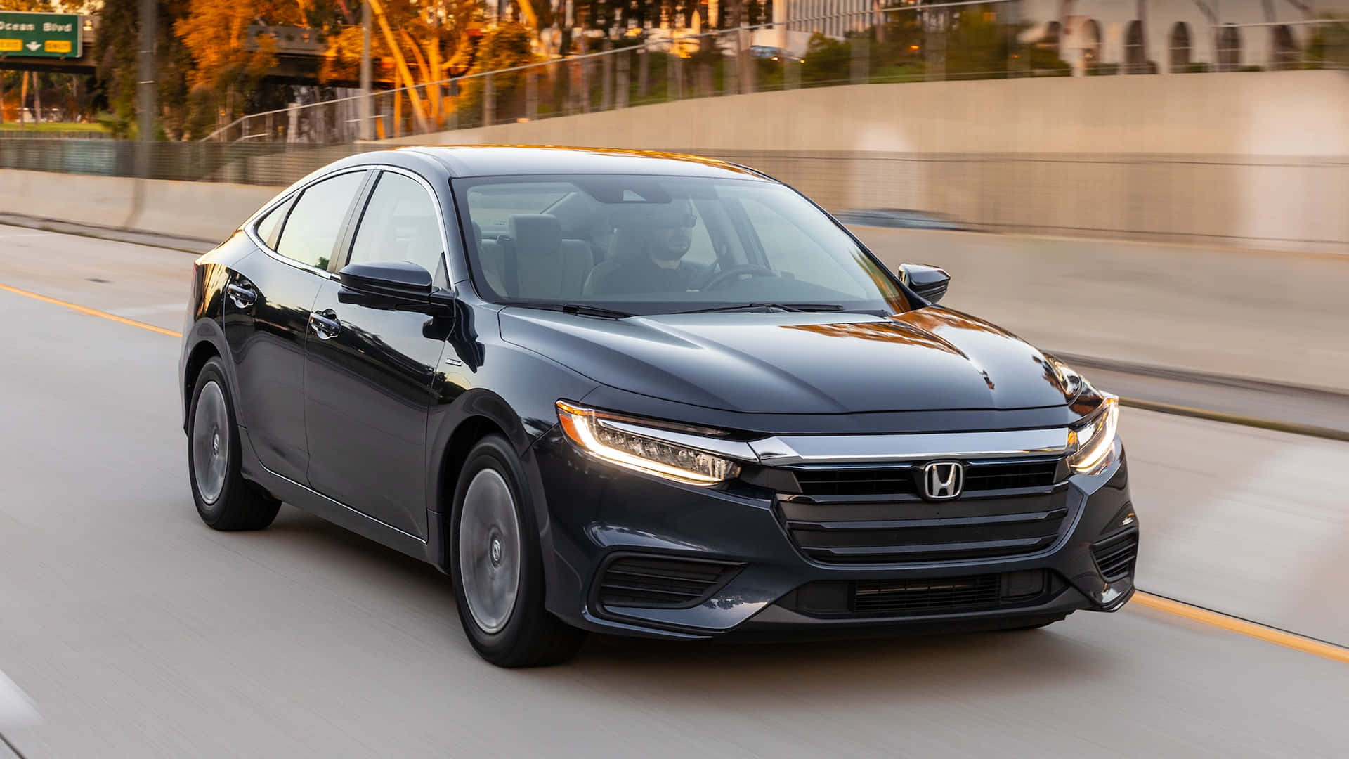 Honda Insight 桌布 壁紙 — 一輛時尚的黑色本田轎車在陽光明媚的高速公路上疾馳，背景呈現動態模糊效果。
