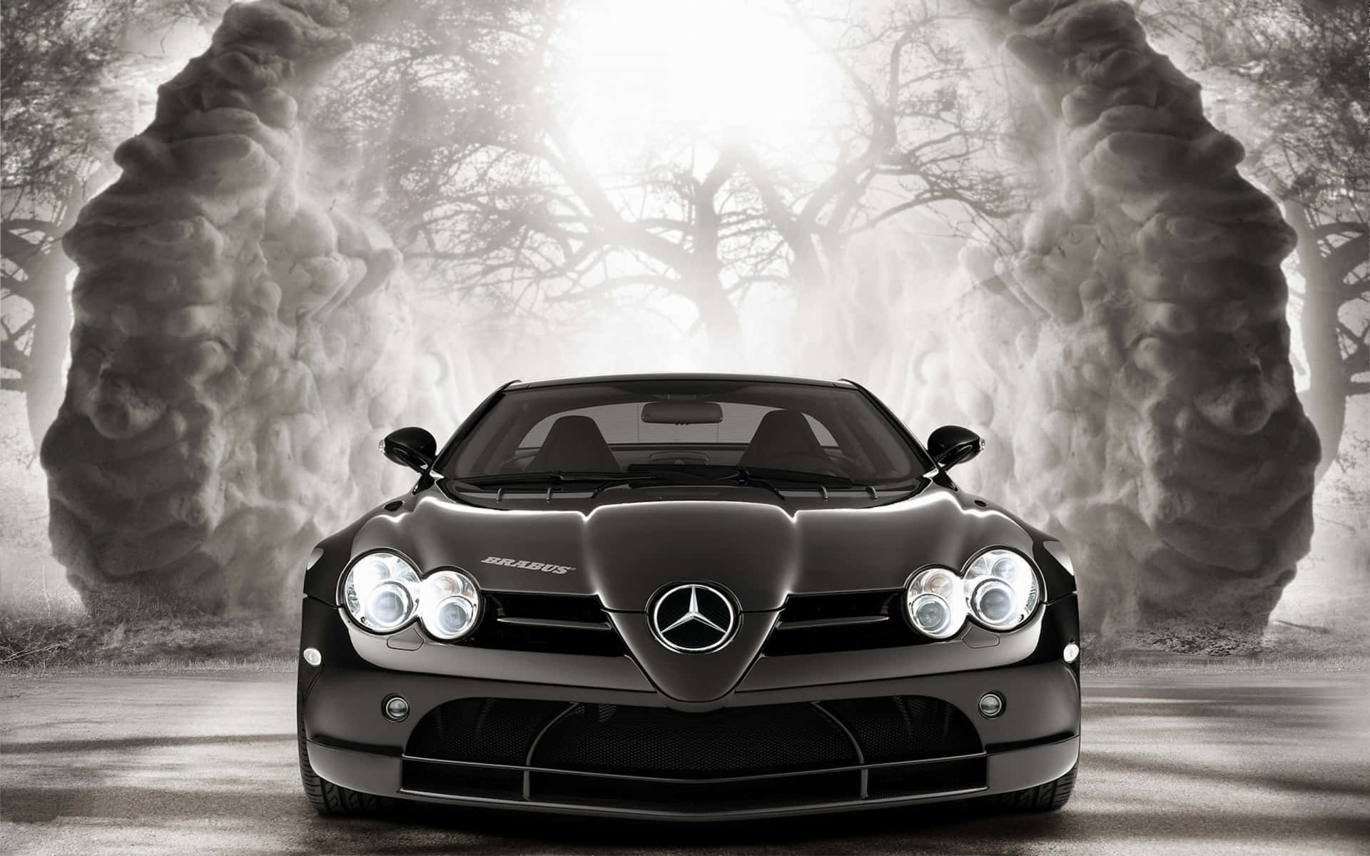 Mercedes 桌布 壁紙 — 一輛時尚的黑色梅賽德斯-奔馳 Brabus 跑車在超現實森林中，被高聳、霧氣瀰漫的石拱門框住，在戲劇性的背光下閃閃發光。