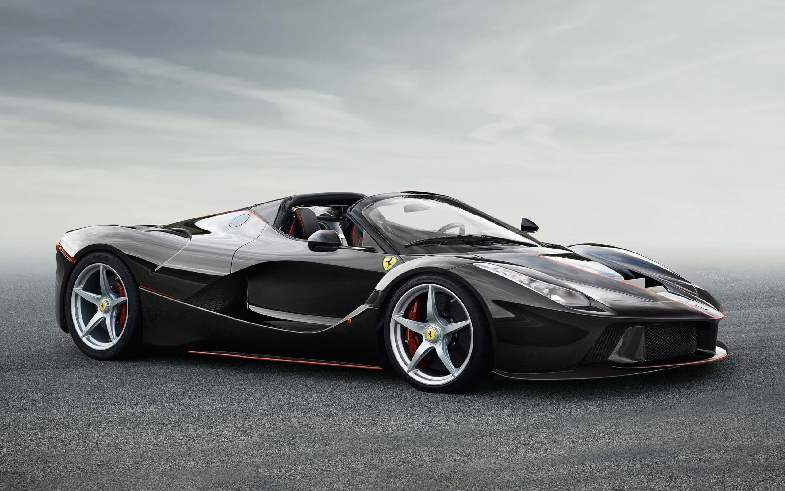 Ferrari Laferrari 桌布 壁紙 — 一輛時尚的黑色法拉利 LaFerrari Aperta，帶有紅色點綴和銀色輪圈，停在灰色瀝青路面上，天空多雲。