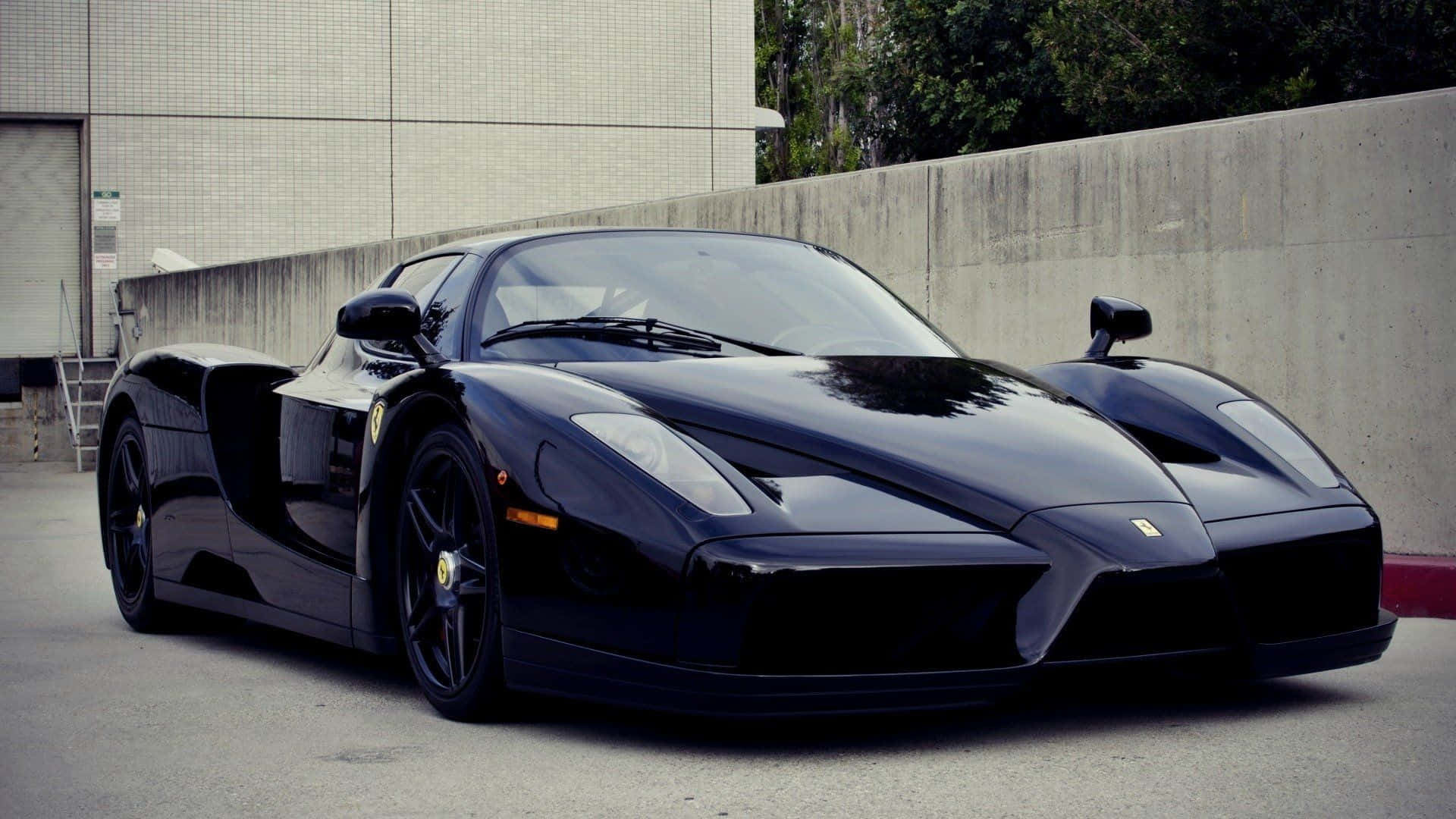 Ferrari Enzo 桌布 壁紙 — 一輛時尚的黑色法拉利Enzo跑車停在混凝土上，背景是現代建築和綠植。