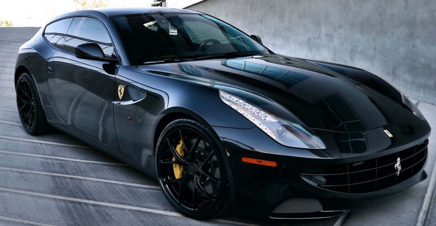 Ferrari Ff 桌布 壁紙 — 一輛時尚的黑色法拉利跑車，帶有黃色制動卡鉗，停在灰色牆壁前的混凝土表面上。