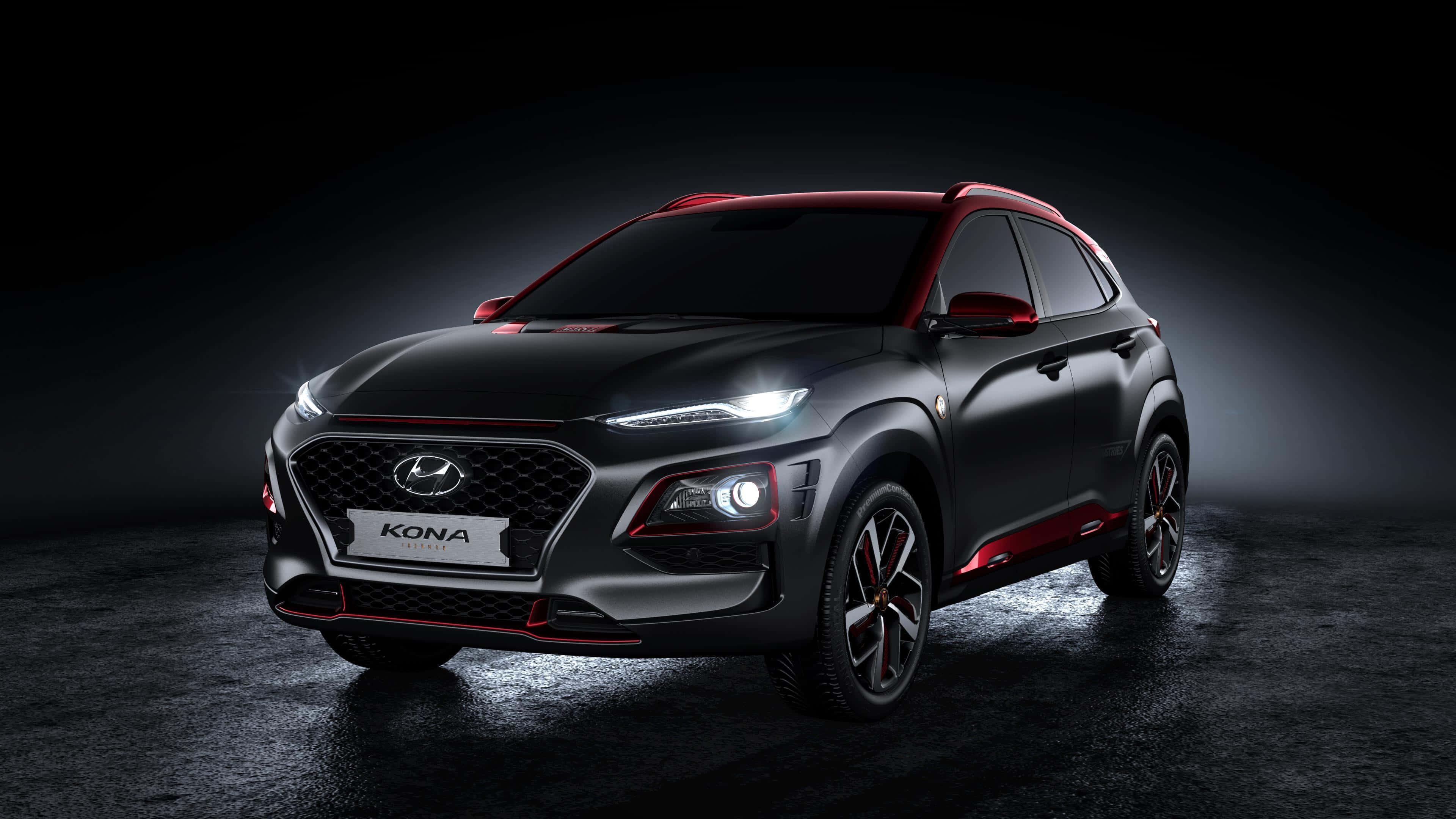 Hyundai Kona 桌布 壁紙 — 一輛時尚的黑色現代Kona，帶有紅色點綴，在黑暗背景下於戲劇性的工作室燈光下閃耀。