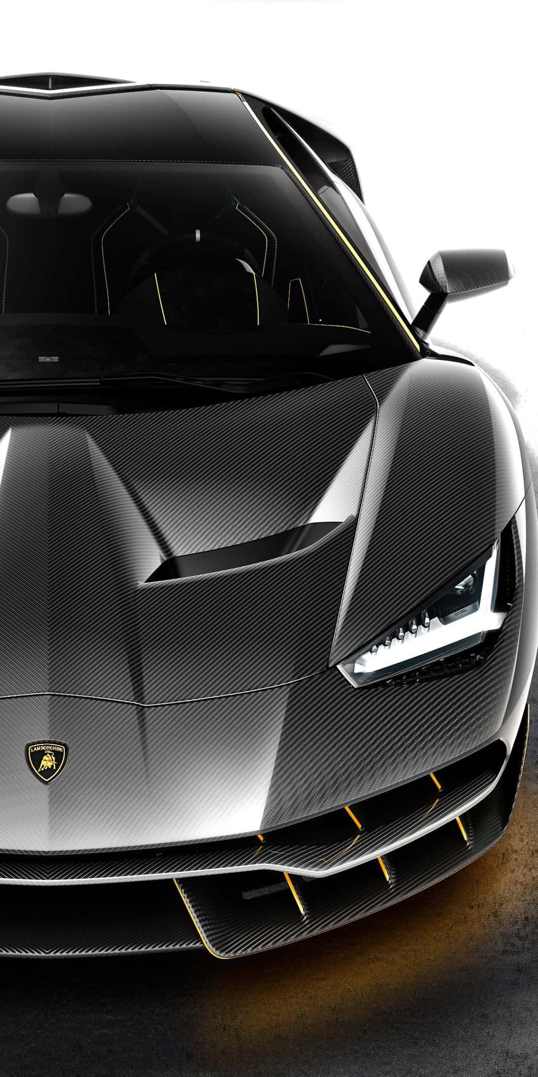Pixel 3 Lamborghini 桌布 壁紙 — 一輛時尚的黑色碳纖維藍寶堅尼跑車，帶有金色點綴和銳利的棱角頭燈。