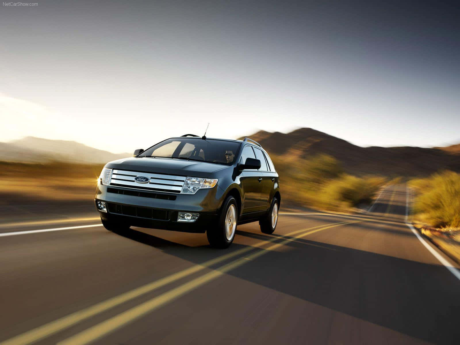 Ford Edge 桌布 壁紙 — 一輛時尚的黑色福特 Edge SUV 在沙漠高速公路上奔馳，帶有模糊的動態和金色的日落光線。