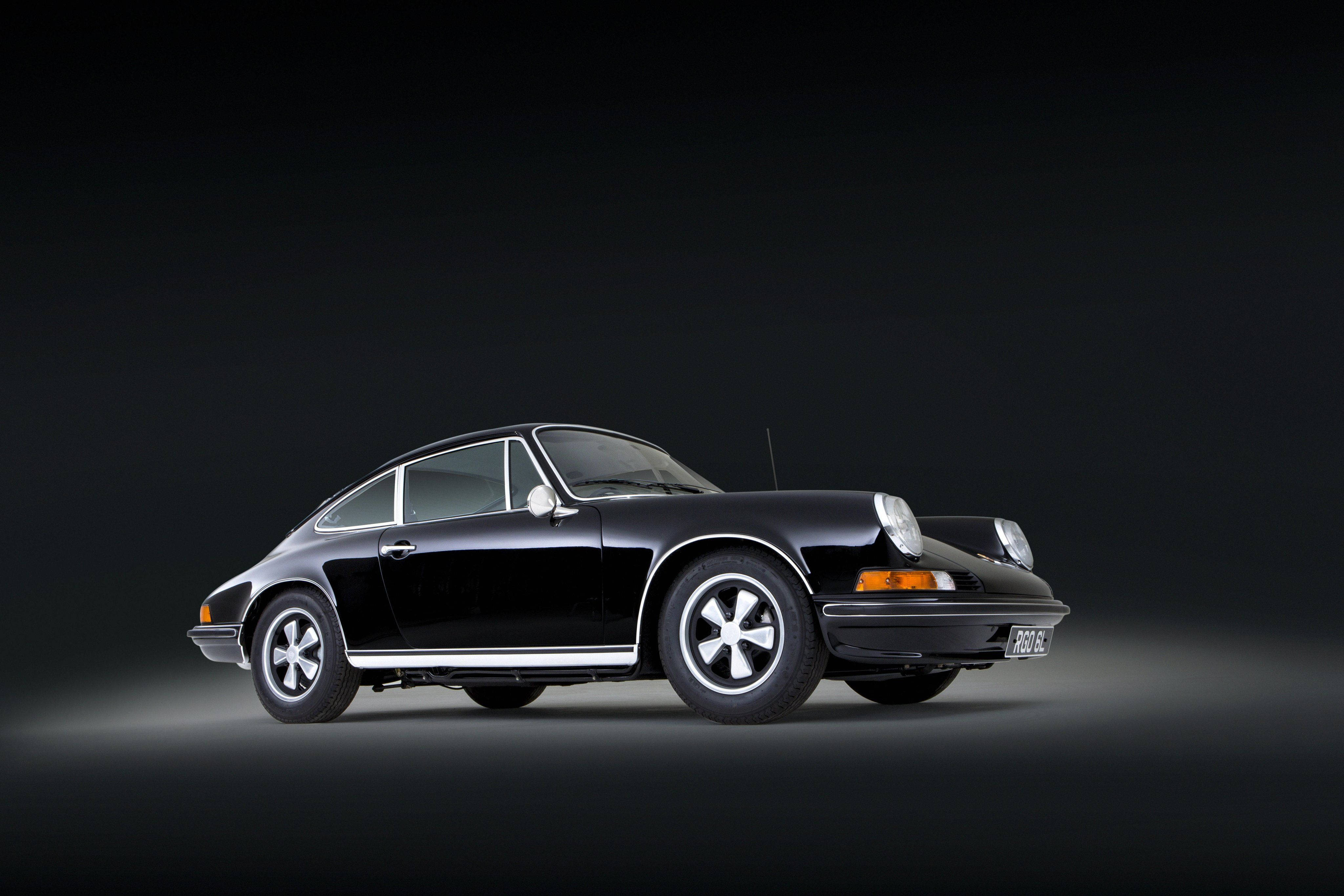Porsche 911 桌布 壁紙 — 一輛時尚的黑色經典保時捷911雙門跑車在攝影棚燈光下，在深色漸變背景中閃耀。