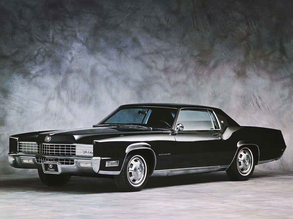 Cadillac 桌布 壁紙 — 一輛時尚的黑色經典凱迪拉克Coupe DeVille在攝影棚燈光下閃閃發光，背景是煙霧灰。