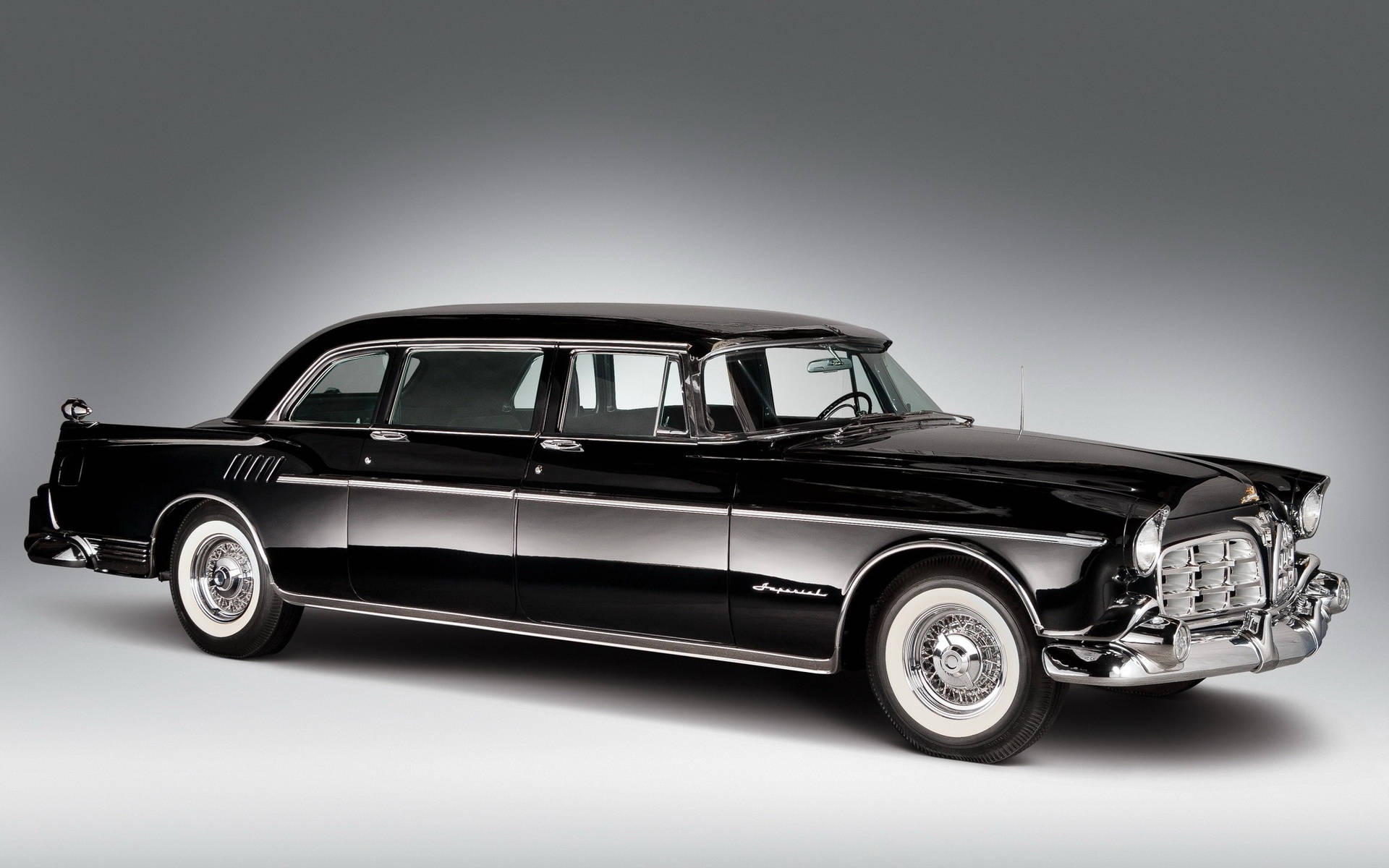 Chrysler 桌布 壁紙 — 一輛時尚的黑色經典汽車，帶有鍍鉻裝飾和白色牆壁輪胎，背景為漸變灰色工作室背景。
