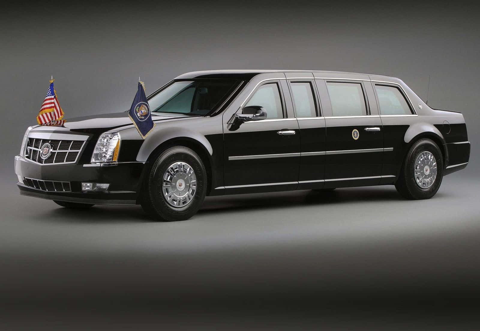 Cadillac 桌布 壁紙 — 一輛時尚的黑色總統豪華轎車，前格柵上展示美國國旗和總統旗。