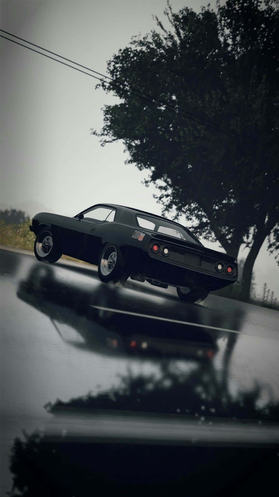 Fast And Furious 9 桌布 壁紙 — 一輛時尚的黑色肌肉車在濕滑的雨路上滑行，其倒影映照在潮濕的瀝青上，天空陰沉。