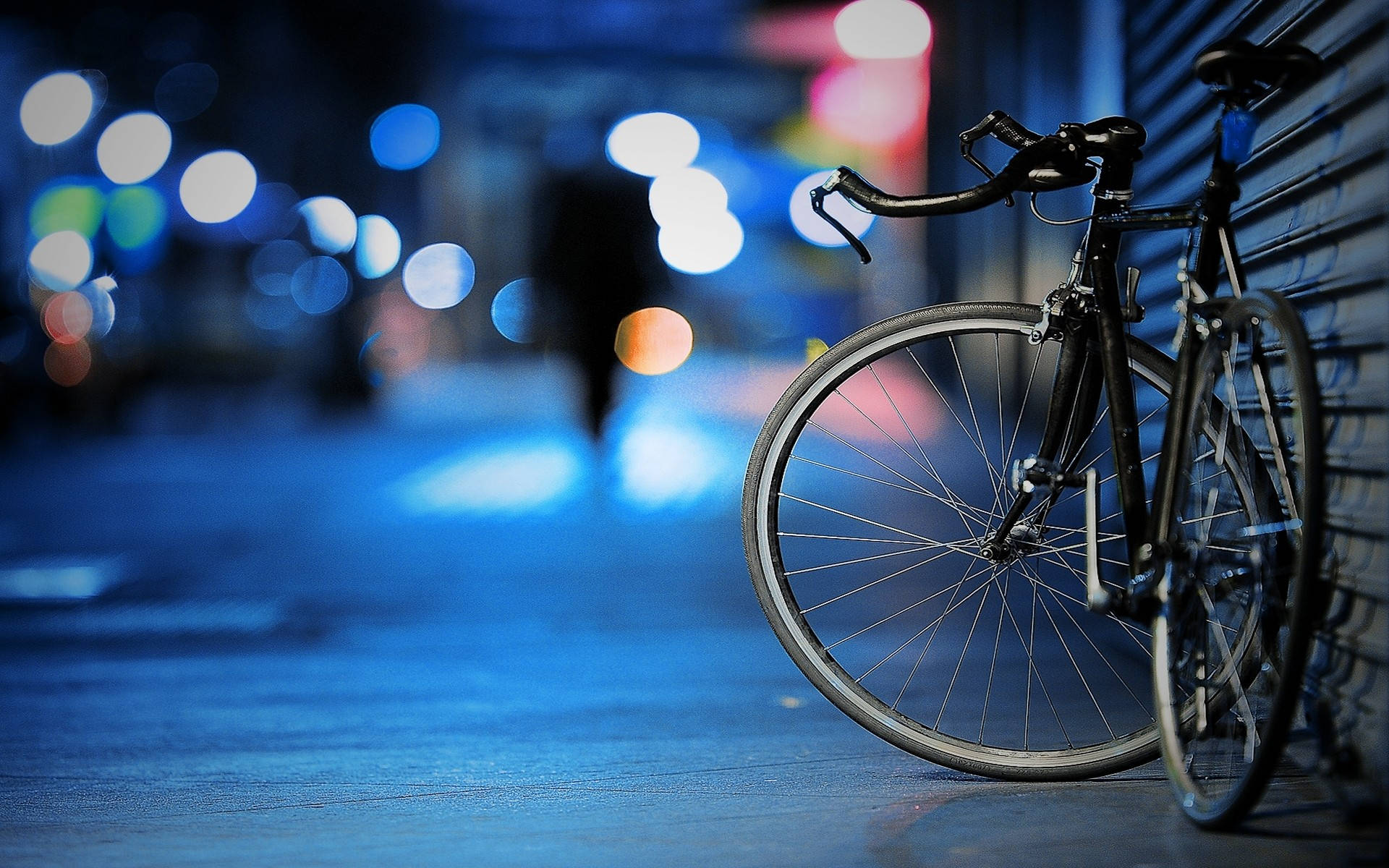 Bicycle 桌布 壁紙 — 一輛時尚的黑色自行車靠在霓虹燈閃爍的夜街金屬捲簾上，背景有散景燈光閃爍。