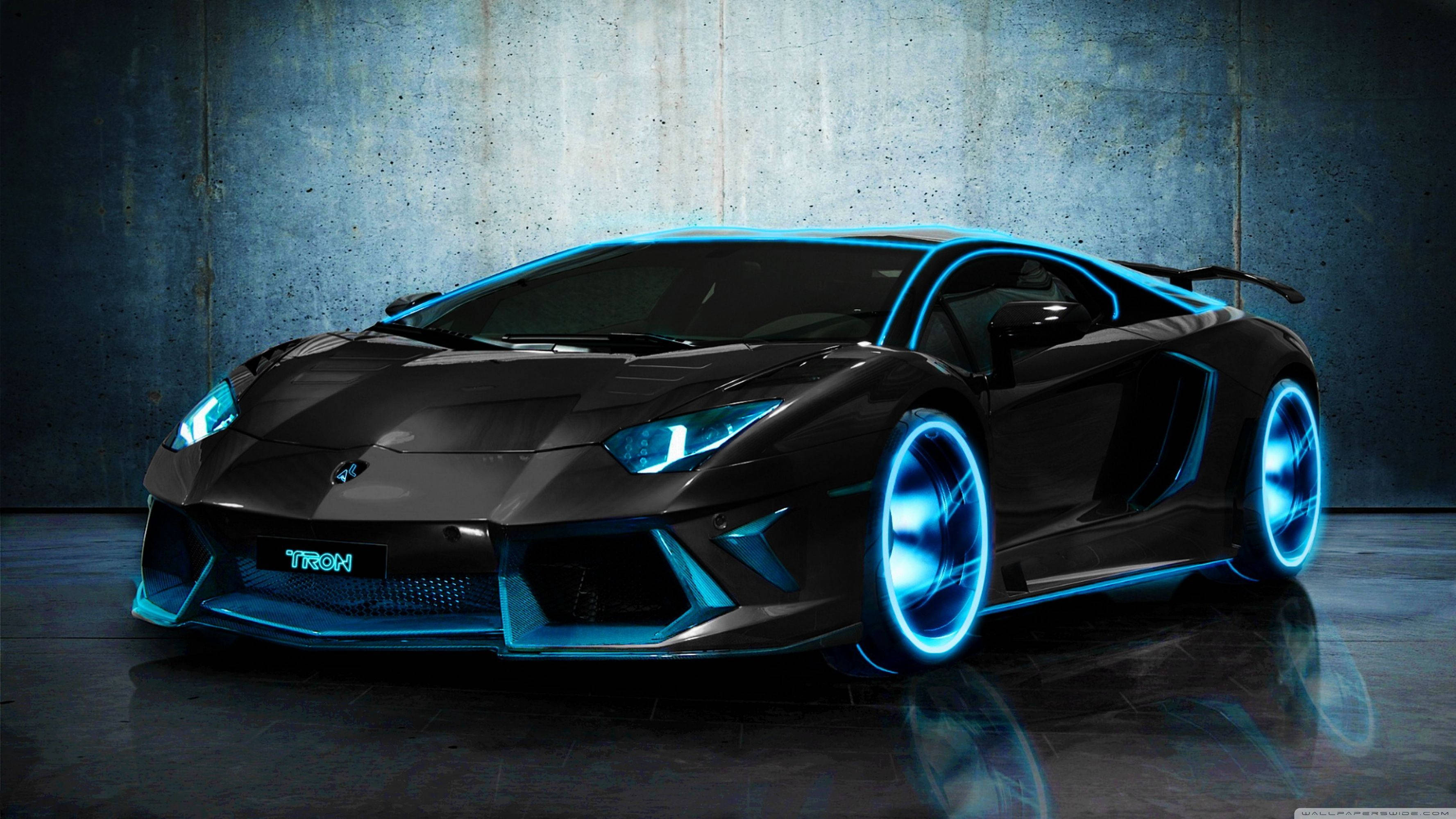 Luxury 桌布 壁紙 — 一輛時尚的黑色藍寶堅尼 Aventador，帶有發光的藍色霓虹燈飾和車輪，在昏暗的工作室中靠著紋理混凝土牆。