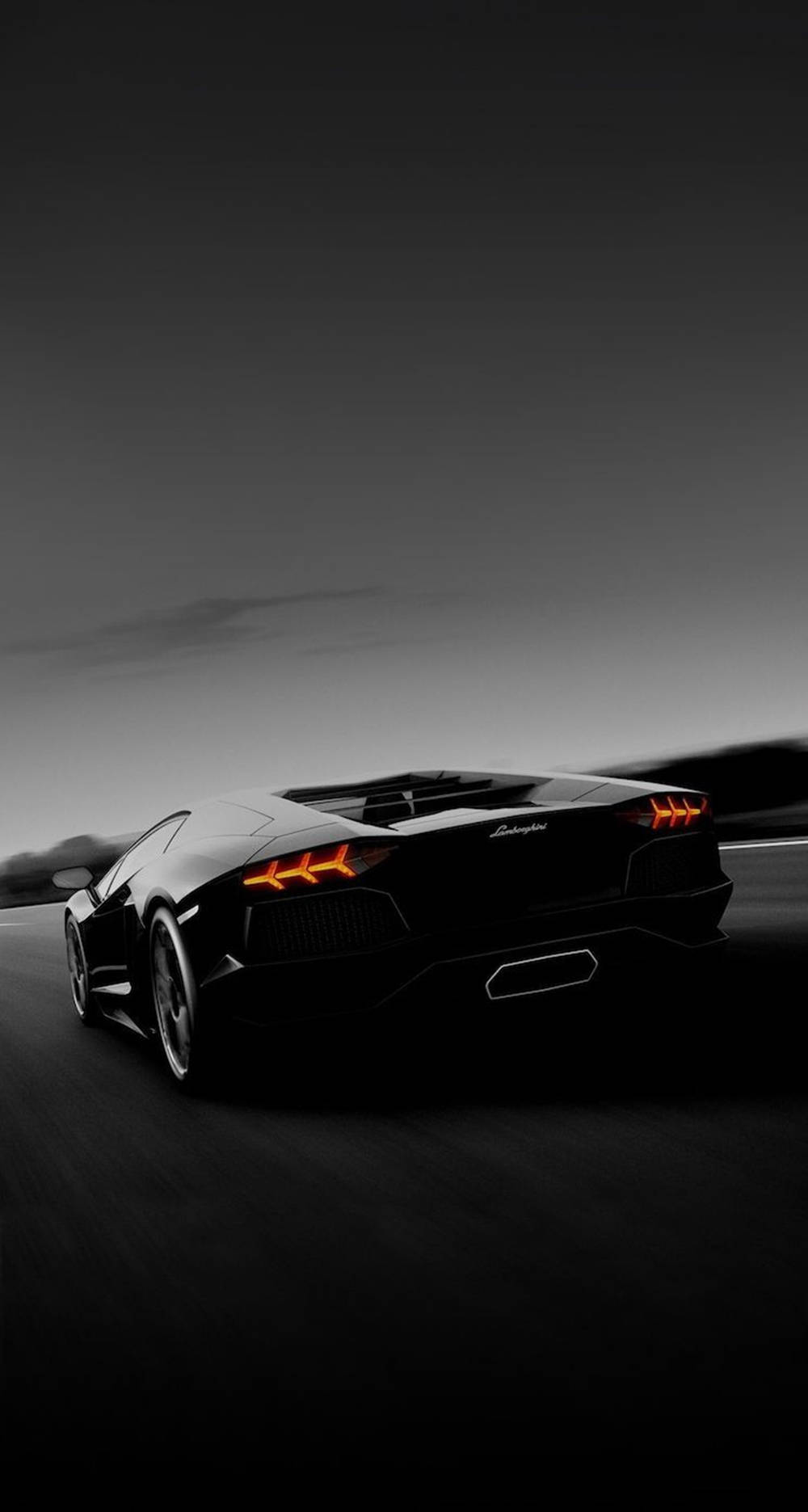 黑色 桌布 壁紙 — 一輛時尚的黑色藍寶堅尼Aventador在黑暗的道路上奔馳，橙色尾燈閃爍，映襯著陰沉的暮色天空。