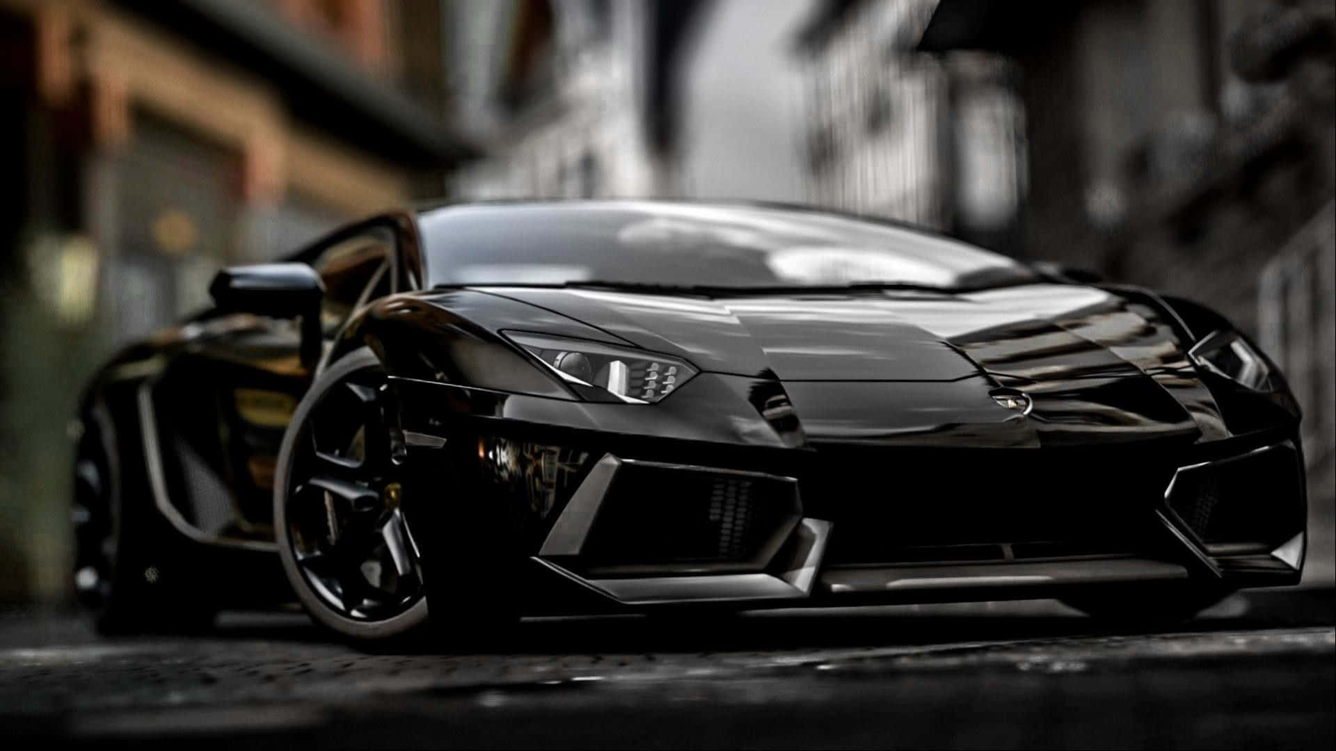 Best Cars 桌布 壁紙 — 一輛時尚的黑色藍寶堅尼跑車在都市街燈下閃耀，淺景深凸顯其侵略性設計。