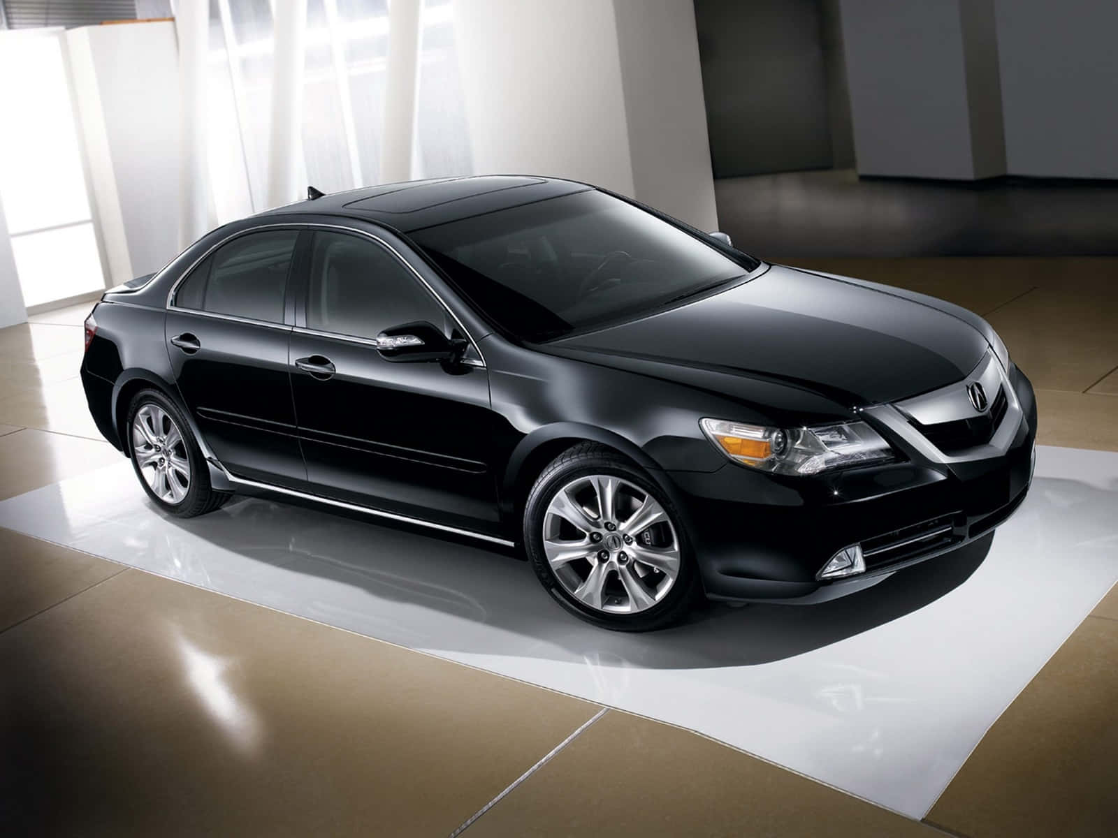 Acura 桌布 壁紙 — 一輛時尚的黑色豪華轎車在工作室燈光下，在白色平台上閃閃發光，位於簡約現代展廳。