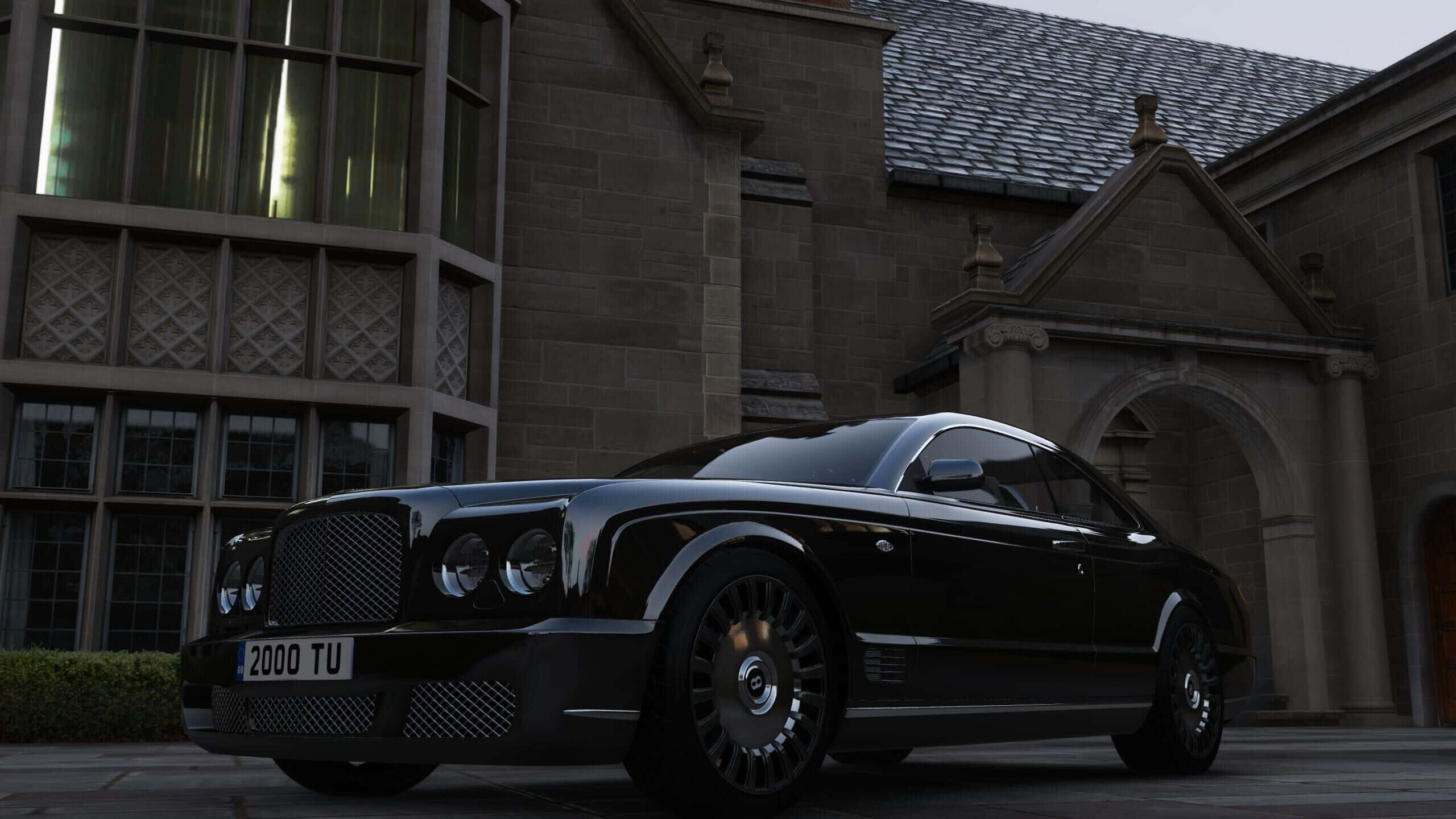 Bentley Brooklands 桌布 壁紙 — 一輛時尚的黑色賓利 Continental Flying Spur 在黃昏時停在一座宏偉的石砌豪宅前。